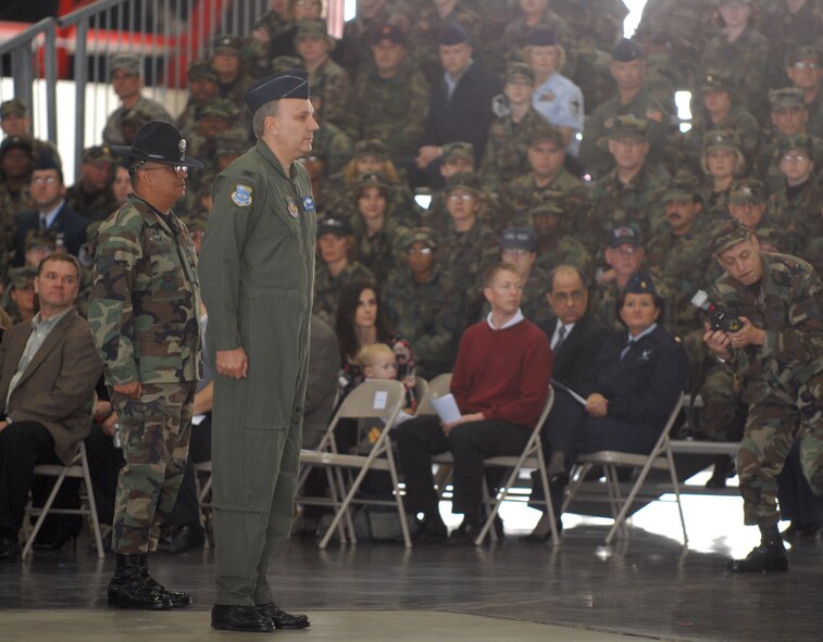 A training instructor (left) and the vice commander of the 932nd Airlift Wing, Col. Jeff Johnson, look over the Airmen assembled inside the hangar before the start of ceremonies welcoming Col. John (Jay) C. Flournoy, Jr.