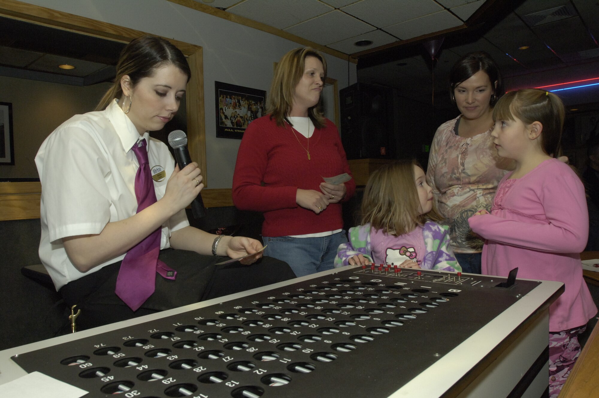 FAIRCHILD AIR FORCE BASE, Wash. – Amanda Thomas, 92nd Services Squadron, double checks a group of patron’s bingo cards to announce a winner at the Totally Awesome 80’s celebration Jan. 18. Patrons who won received various prizes to include 92nd SVS gift certificates and other donated door prizes. (U.S. Air Force Photo/Senior Airman Eunique Stevens)   