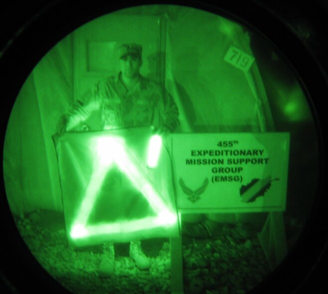 First Lt. TJ Turner, a member of the 455th Expeditionary Mission Support Group, is shown through night vision goggles holding TRON III (left) and TRON I. Air Force Research Laboratory partnered with industry to develop the identification system to save lives and enhance combat effectiveness. (Air Force photo)