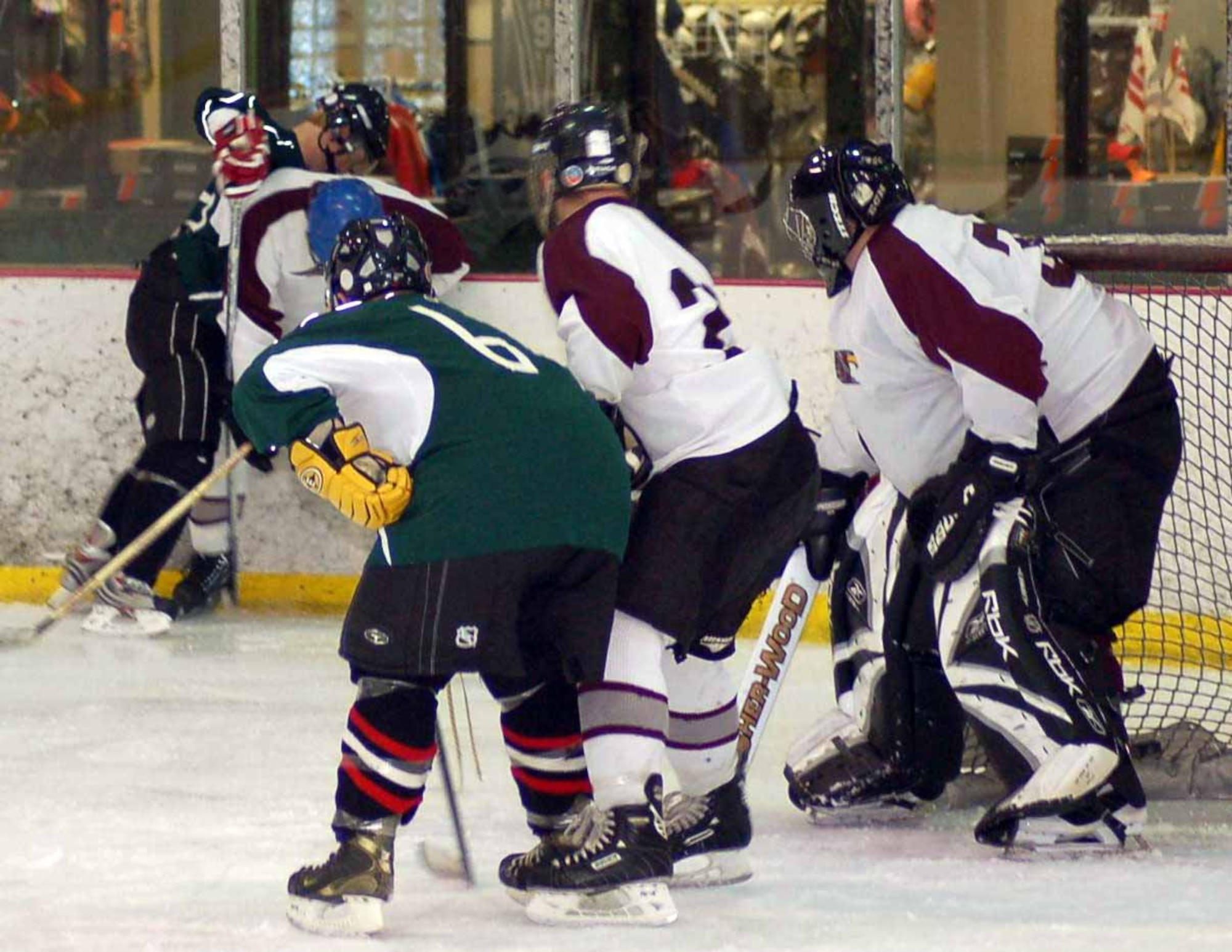 Tinker Hawks I goaltender Brad Poarch keeps a close eye on the action in the corner as defenseman Chris Beatty tries to keep control of the puck. The Hawks won the Jan. 20 game against the P-Men 7-4 at the Blazers Ice Centre. (Air Force photo by John E. Banks)
 
