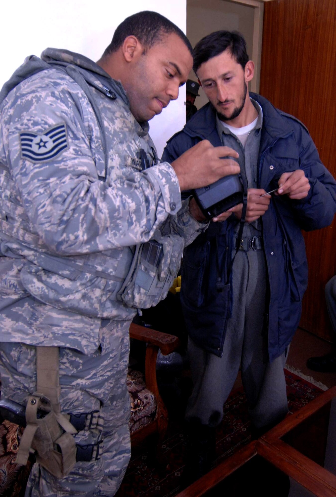 Tech. Sgt. Francis Warren collects biometric information from a Kohistan II district Afghanistan national police noncommissioned officer Jan. 14 at Bagram Air Base, Afghanistan. The information is compiled in a database used to identify Afghans the Provincial Reconstruction Teams interact with. Sergeant Warren is deployed from Bolling Air Force Base, D.C., and is currently assigned to the Bagram Provincial Reconstruction Team. (U.S. Air Force photo/Tech. Sgt. James Law) 
