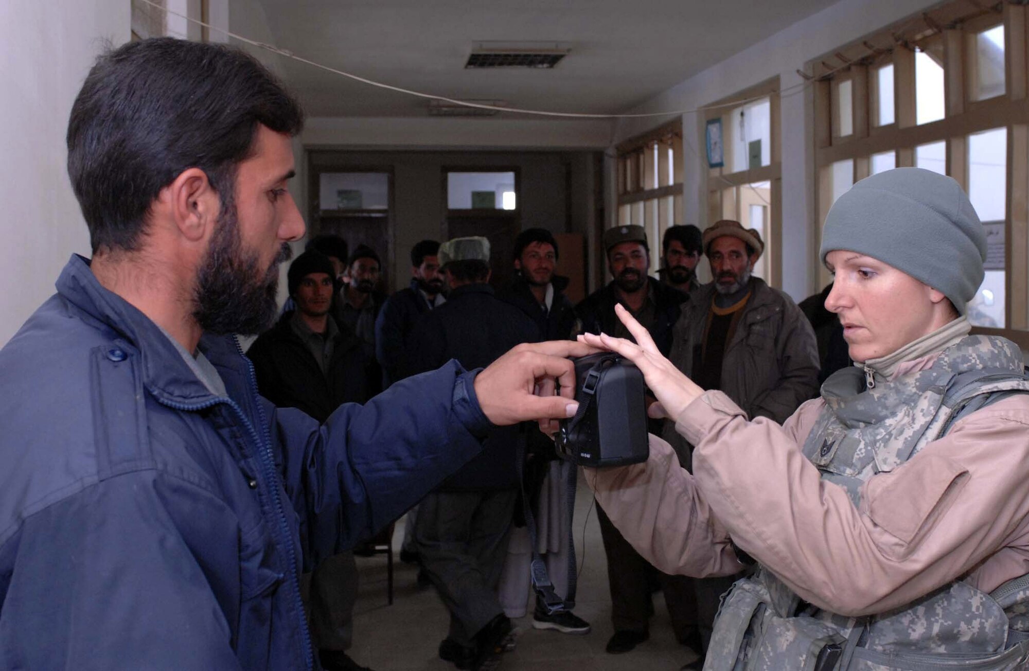 Tech. Sgt. Buffie Verhagen obtains the finger print of a Kohistan II district Afghanistan national police noncommissioned officer Jan 14 at Bagram Air Base, Afghanistan. The fingerprint is cataloged in a database containing biometric information used to identify Afghans the Provincial Reconstruction Teams interact with. Sergeant Verhagen is deployed from Sheppard Air Force Base, Texas, and is currently assigned to the Bagram Provincial Reconstruction Team. (U.S. Air Force photo/Tech. Sgt. James Law) 