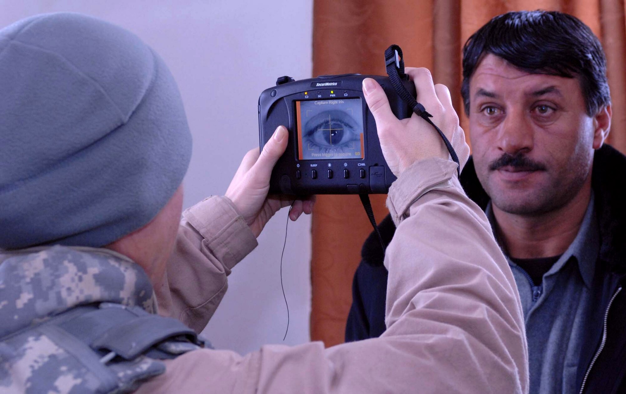 Tech. Sgt. Buffie Verhagen takes a picture of Mouhammed Naieem's iris Jan. 14 at Bagram Air Base, Afghanistan. The photo is cataloged in a database containing biometric information used to identify Afghans the Provincial Reconstruction Teams interact with. Sergeant Verhagen is deployed from Sheppard Air Force Base, Texas, and is currently assigned to the Bagram Provincial Reconstruction Team. Mr. Naieem is the Kohistan II district chief of police. (U.S. Air Force photo/Tech. Sgt. James Law) 
