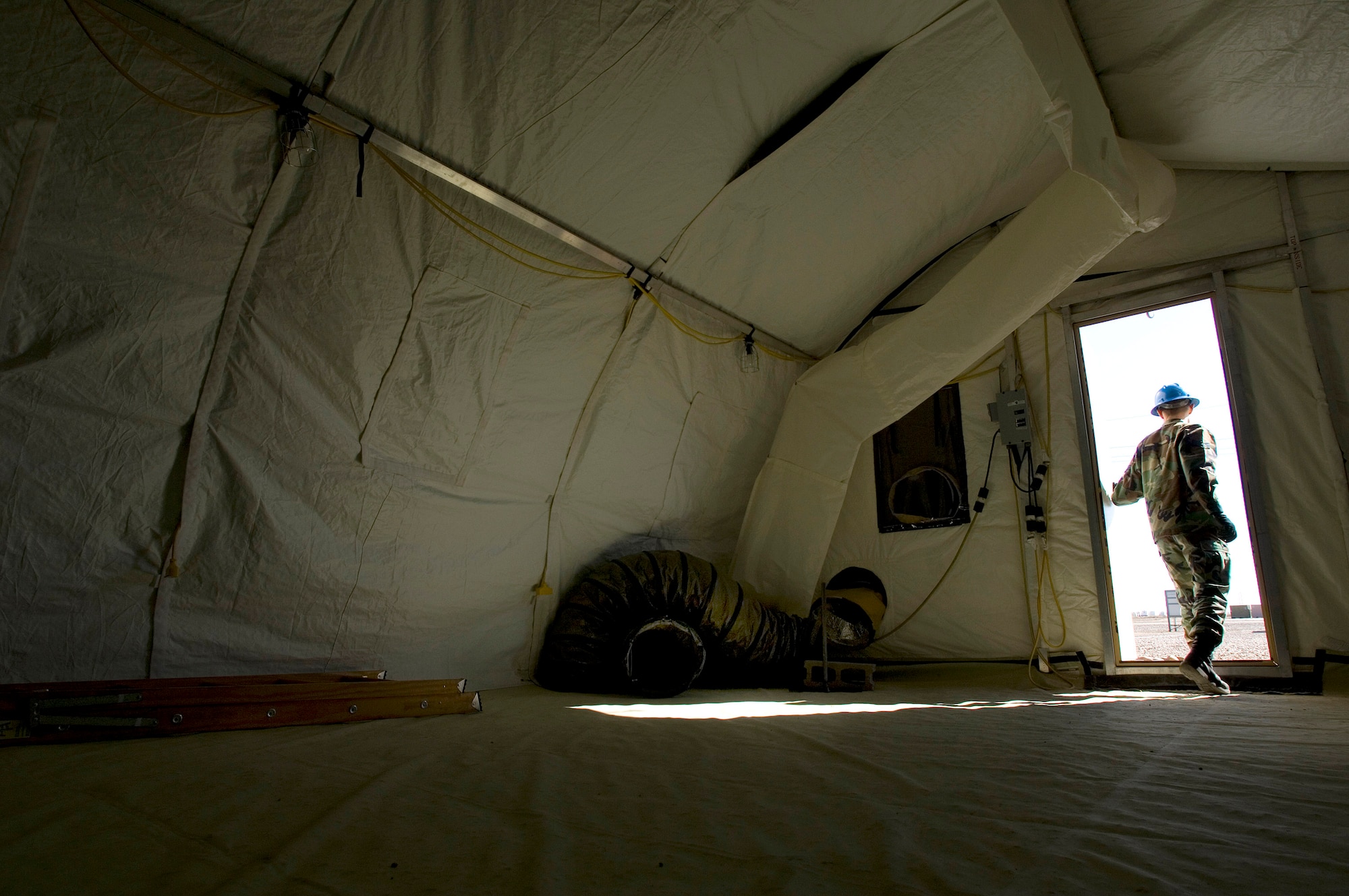 Senior Airman Andy Karabelski steps out of a small shelter system after a final inspection during a Jan. 16 exercise at Holloman Air Force Base, N.M. Airman Karabelski  is assigned to the from the 49th Material Maintenance Group. Members of the 49th MMG can build a Basic Expeditionary Airfield Resource, or BEAR, in austere conditions anywhere in the world. Airmen of the 49th MMG maintain a constant state of readiness and can be tasked to support any Department of Defense or Federal Emergency Management Agency humanitarian operations along with primary duties of supporting combat operations. (U.S. Air Force photo/Staff Sgt. Bennie J. Davis III) 

