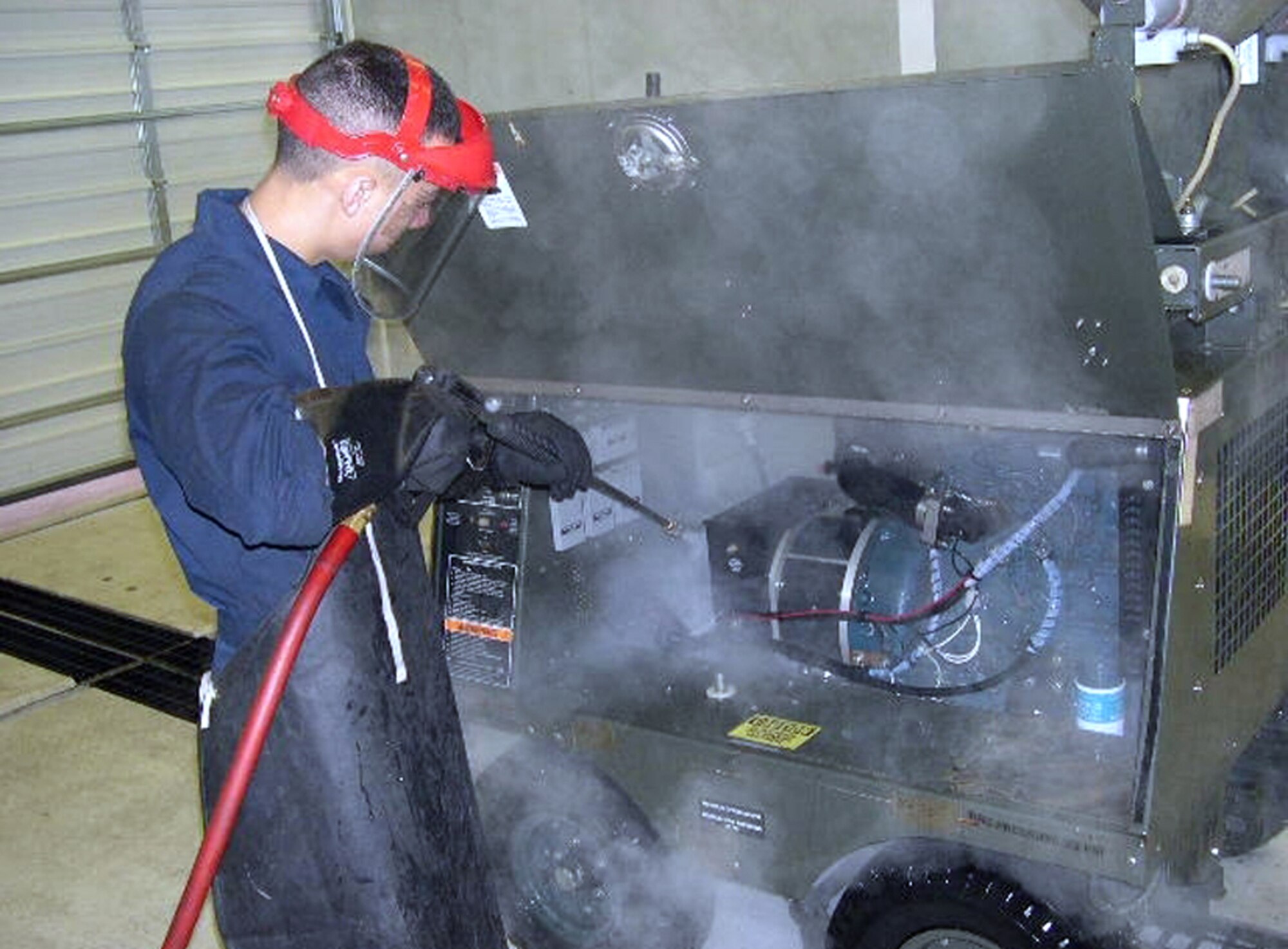Airman 1st Class Herman Bowser, 436th Maintenance Squadron Aerospace Ground Equipment apprentice, utilizes AGE's new washrack to clean AGE equipment. The washrack is a completely self-contained and environmentally-friendly system.  It has a 600-gallon water reservoir that provides wash water.  Runoff water is collected in a center drain, filtered thru another tank and returned to the 600 gallon reservoir for continued use without waste water entering ground drains, which saves an estimated 21,000 gallons of water annually. (U.S. Air Force photo/Staff Sgt. Matthew Hugo) 