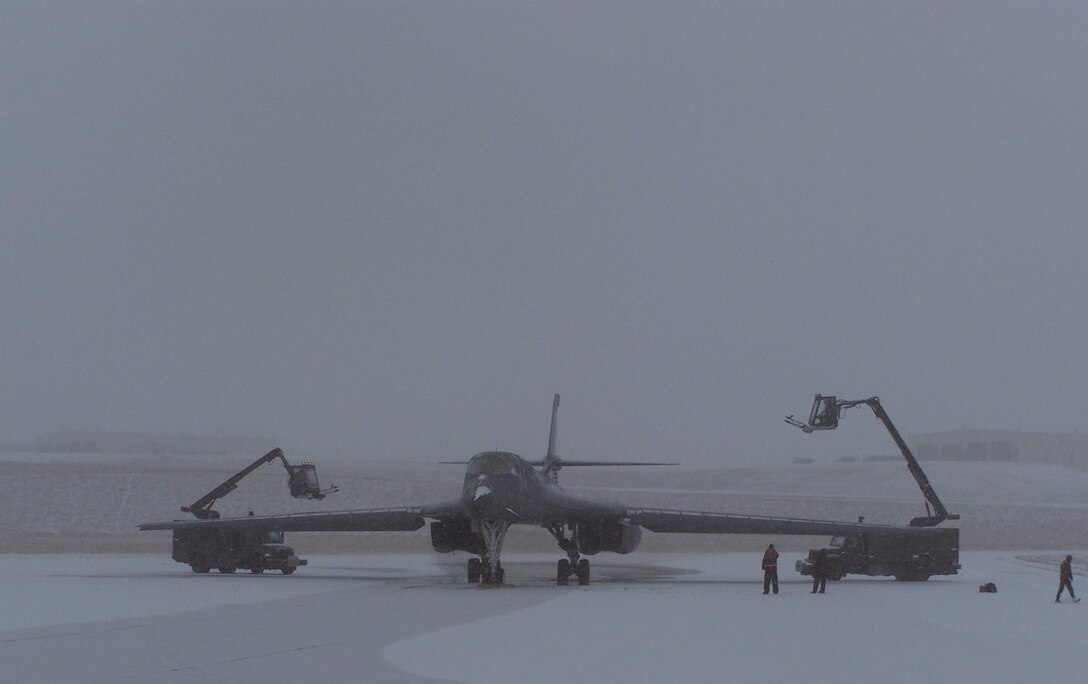 Members of the 28th Maintenance Group fight the South Dakota elements to de-ice a B-1 recently, as part of the 37th Bomb Squadron's deployment to Southwest Asia. The deployment package, composed of more than 200 Airmen, is supporting the 379th Air Expeditionary Wing with aircraft, aircrew, maintainers and other expeditionary combat support Airmen.(US Air Force Photo / Senior Airman Benjamin Tallman) 