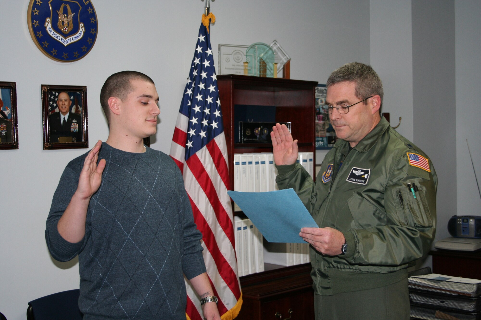 WRIGHT-PATTERSON AFB, Ohio - Lt. Col. John Schulte, 910th Mission Support Group Deputy Commander, gives the Oath of Enlistment to his son Bray Schulte Jan. 18, 2008.  Bray will be assigned to the 445th Airlift Wing, working in the Security Forces Squadron.  Bray's mother, Col. Anna Schulte, is the 445th Maintenance Group commander. (U.S. Air Force photo/Laura Darden)