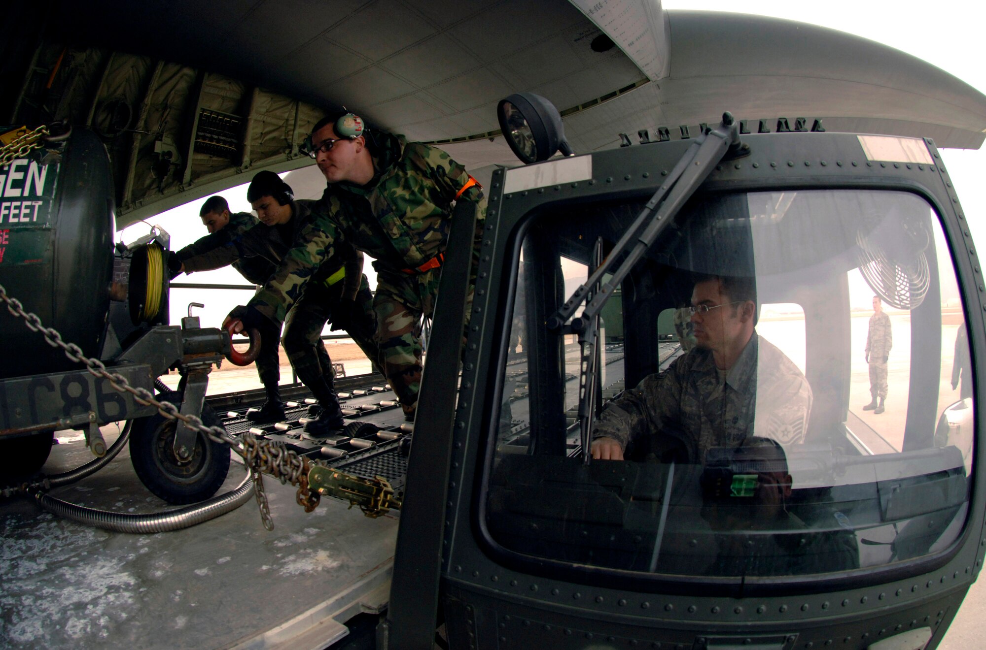 Tech. Sgt. Anthony Malmquist assists Senior Airman Tom Reilly (2nd from right) in loading 25,000 pounds of cargo aboard a C-130 Hercules Jan. 9 at Aviano Air Base, Italy. The cargo, bound for Zaragoza Air Base, Spain, was flown by members of the 38th Airlift Squadron from Ramstein Air Base, Germany, in support of F-16 Fighting Falcons conducting training in Spain. Sergeant Malmquist is an aerial porter, and Airman Reilly is a Rhode Island Air National Guard crew chief. (U.S. Air Force photo/Master Sgt. Scott Wagers) 
