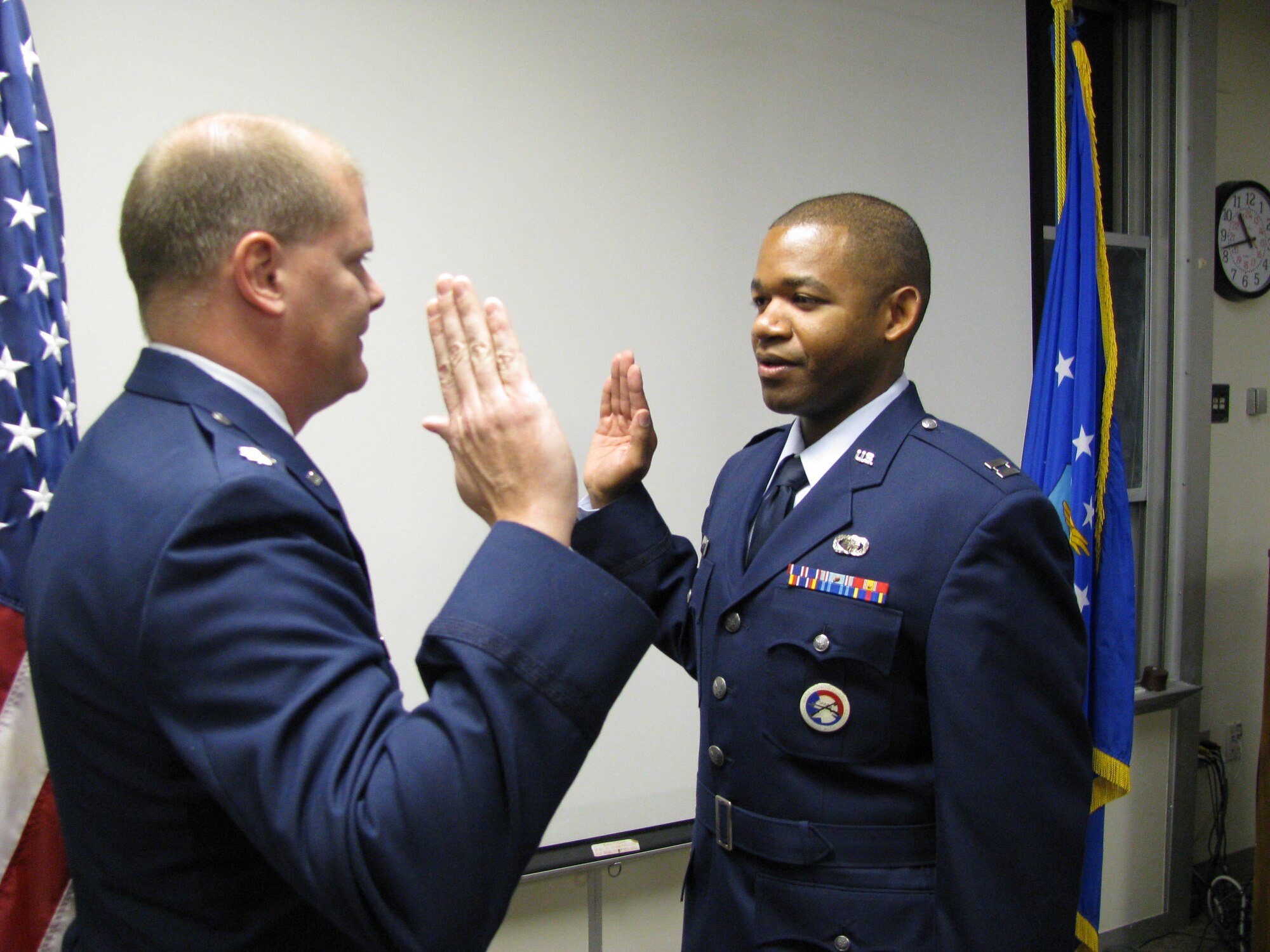 Captain Jonathan Pellum, Heritage Coat program manager, 648th Aeronautical Systems Squadron, recites the oath of office in a ceremony officiated by Lt. Col. Gary Salmans here. The Captain used his promotion ceremony to showcase the proposed Air Force Heritage Service Dress Coat. (U.S. Air Force Photo courtesy of the 648th AESS)