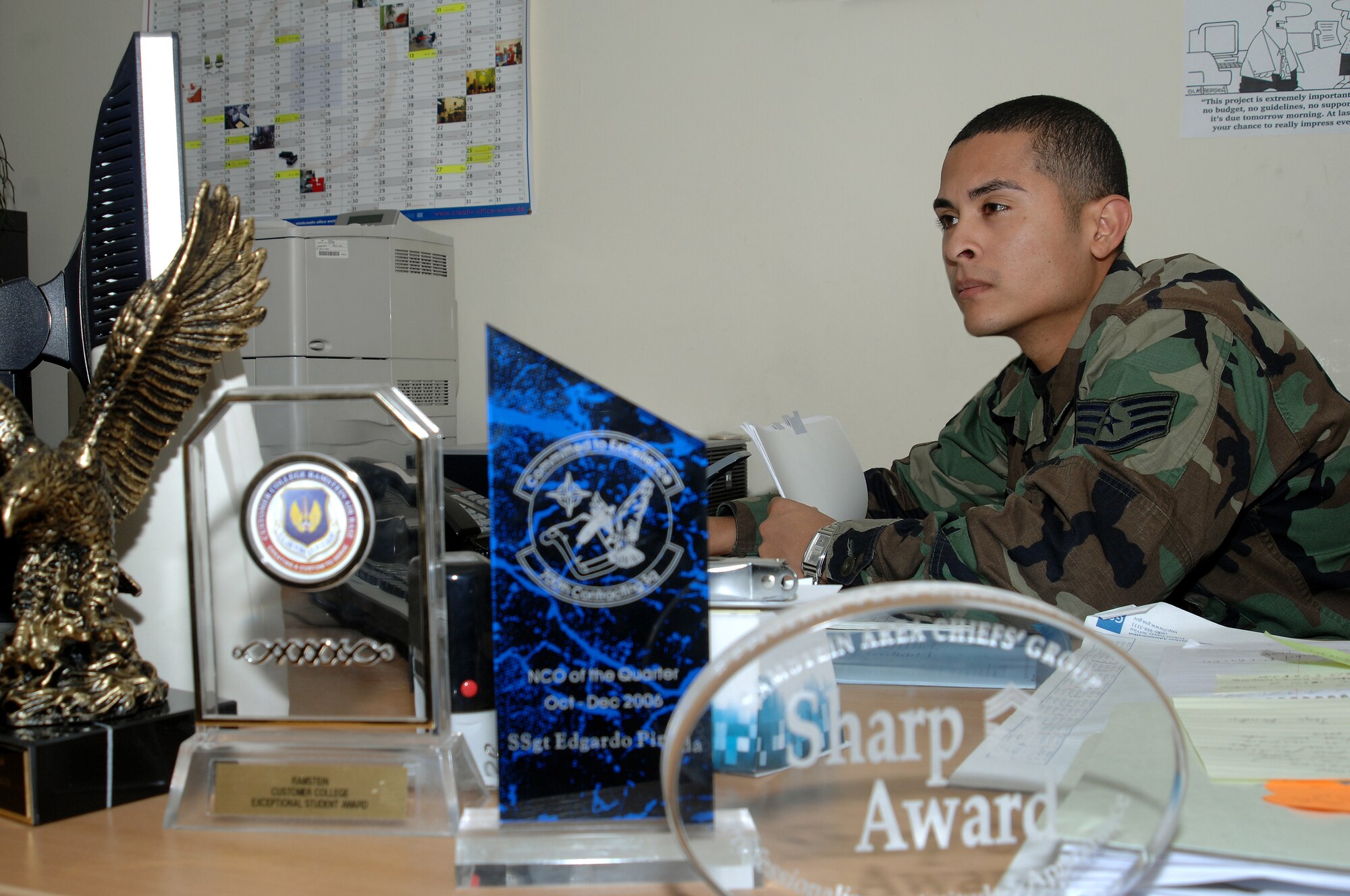 Staff Sgt. Edgardo Pineda, 700th Contracting Squadron, proudly displays his many well-deserved awards while hard at work Jan. 18, at Rhine Ordinance Barracks. Sergeant Pineda is a key contributor to the success of the 700th CONS mission. (U.S. Air Force Photo/A1C Kenny Holston)
