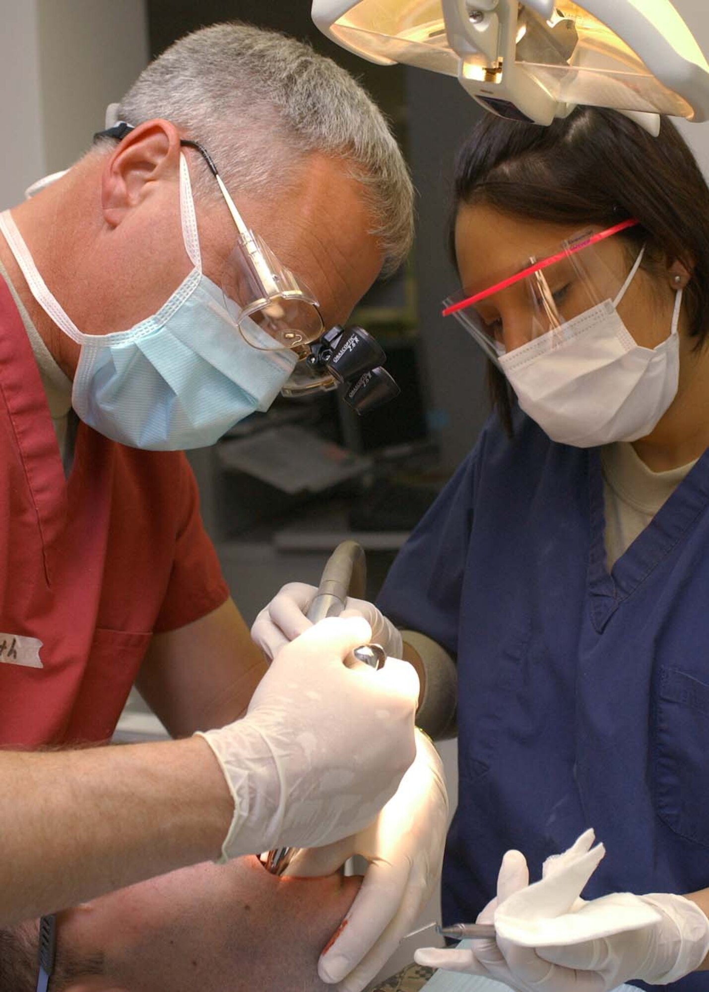 BAGRAM AIR BASE, Afghanistan -- Col. James Lindemuth, dentist, and Staff Sgt. Tanya Hazen, dental technician, of the 455th Expeditionary Medical Group, perform a tooth extraction on a Soldier at Task Force MED’s Craig Joint Theater Hospital here Jan. 20. Lindemuth and Hazen are deployed here from the 60th Dental Squadron at Travis AFB, Calif. (U.S. Air Force photo by Master Sgt. Demetrius Lester)