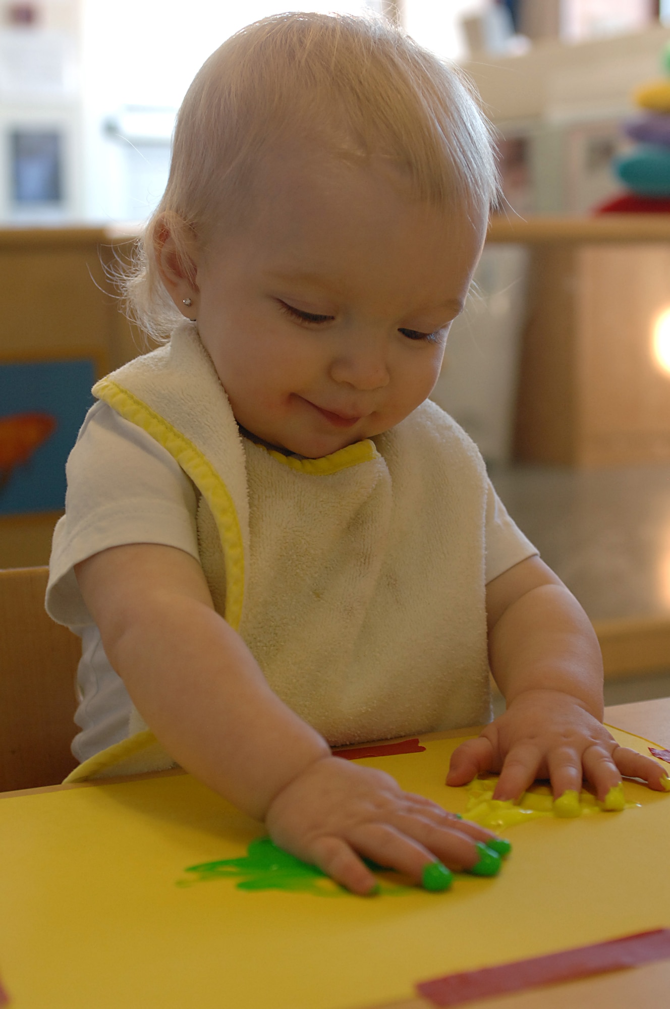 Cameryn Barkhauer, 1-year-old daughter of Staff Sgts. Bradley and Paula Barkhauer, plays with cold paint during an artwork activity Jan. 16 at the CDC East on RAF Lakenheath. The CDC follows lesson plans for each age group and integrates activities that encourages language and communication, lets children explore and discover, and exposes children to changes in their environment. (U.S. Air Force photo by Staff Sgt. Vanessa Young)

