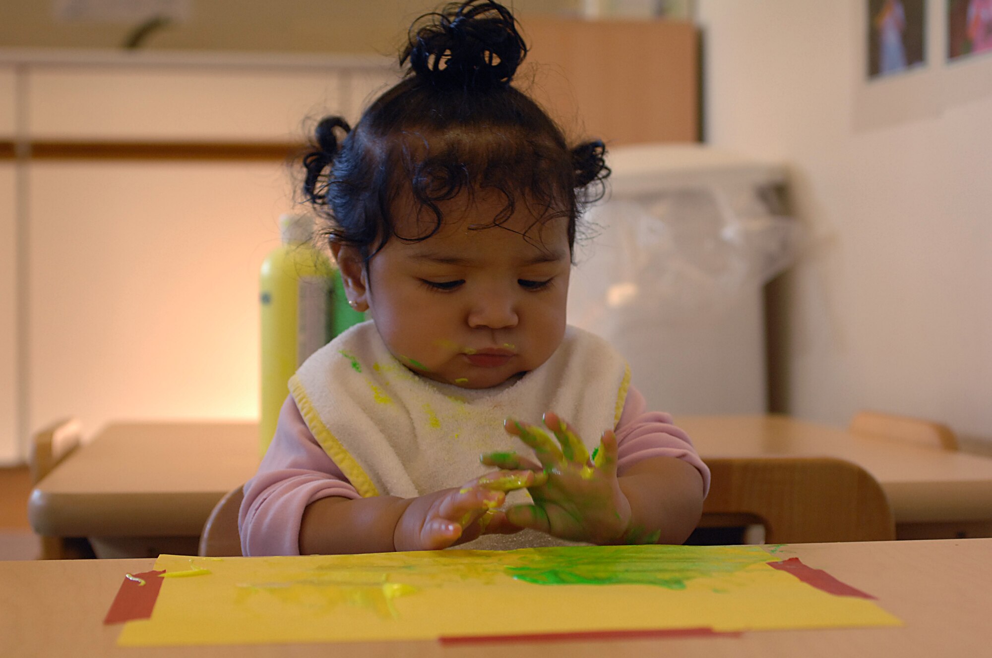 Nyeli Reyes, 10-month-old daughter of Staff Sgt. Sandra Reyes, plays with cold paint during an artwork activity Jan. 16 at the CDC East on RAF Lakenheath. The CDC follows lesson plans for each age group and integrates activities that let them explore and discover, encourage language and communication and exposes them to changes in their environment. (U.S. Air Force photo by Staff Sgt. Vanessa Young)