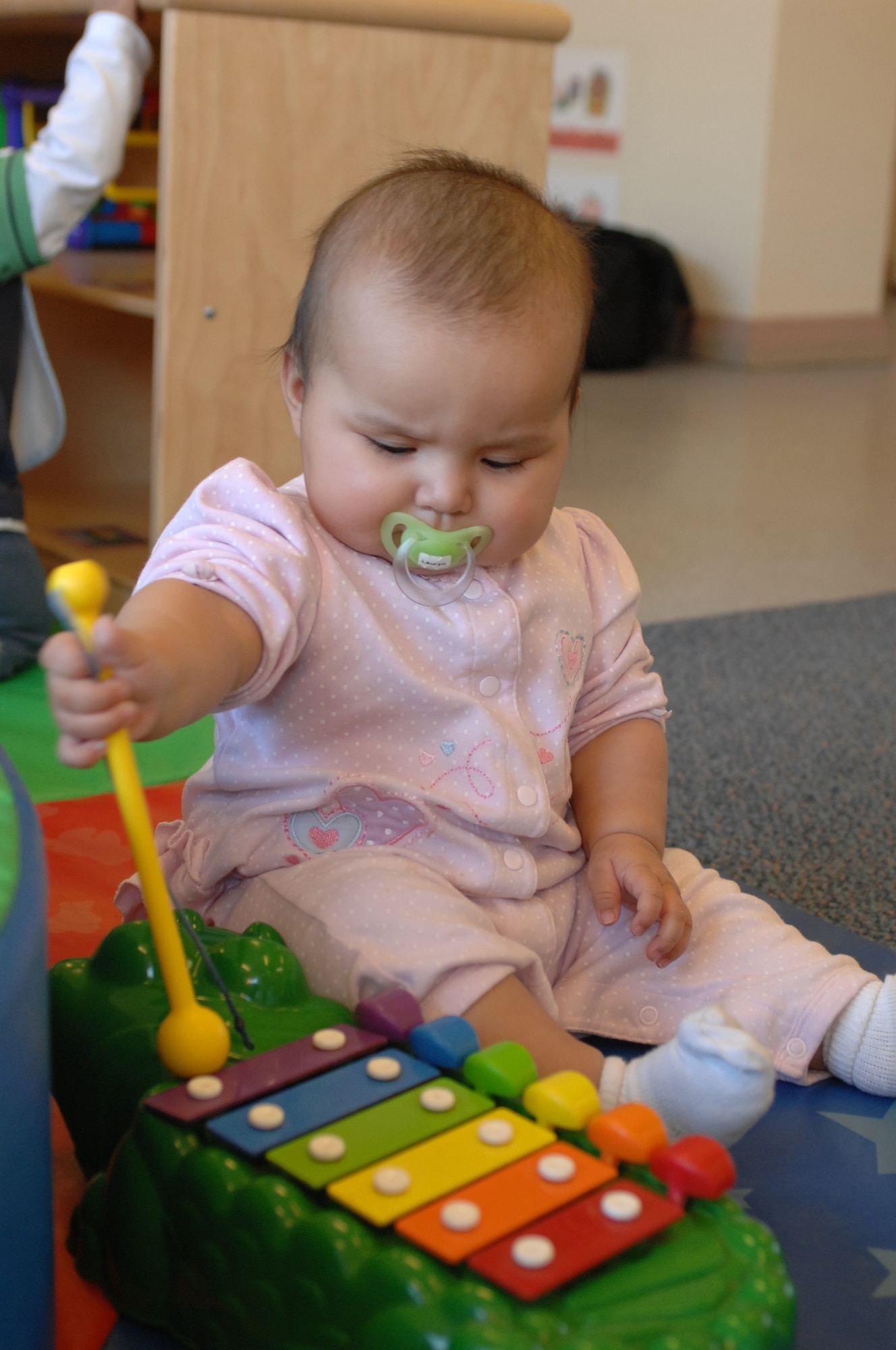 Lauryn Johnson, 7-month-old daughter of Staff Sgts. Andrew and Shauna Johnson, plays with an xylophone in the 6-month to 1-year old room Jan. 16 at the CDC East on RAF Lakenheath. Each room in the CDC has equipment and toys to educate the specific age group. (U.S. Air Force photo by Staff Sgt. Vanessa Young) 