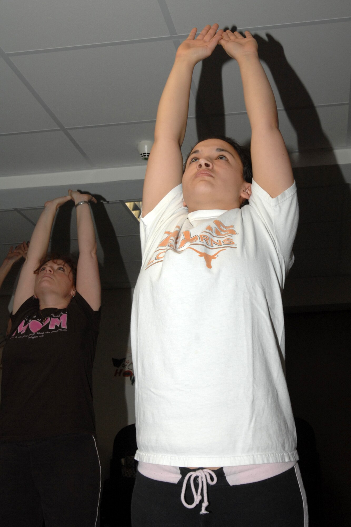 SPANGDAHLEM AIR BASE, Germany – (Right) Jen Kirk, daughter of Chief Master Sgt. Edward Kirk, 52nd Logistics Readiness Squadron, and her mother, Laurie Kirk practice yoga together Jan. 17, 2008. Studies show that working out with a partner increases the chance of overall fitness goal success. (U.S. Air Force photo/Airman 1st Class Jenifer Calhoun)