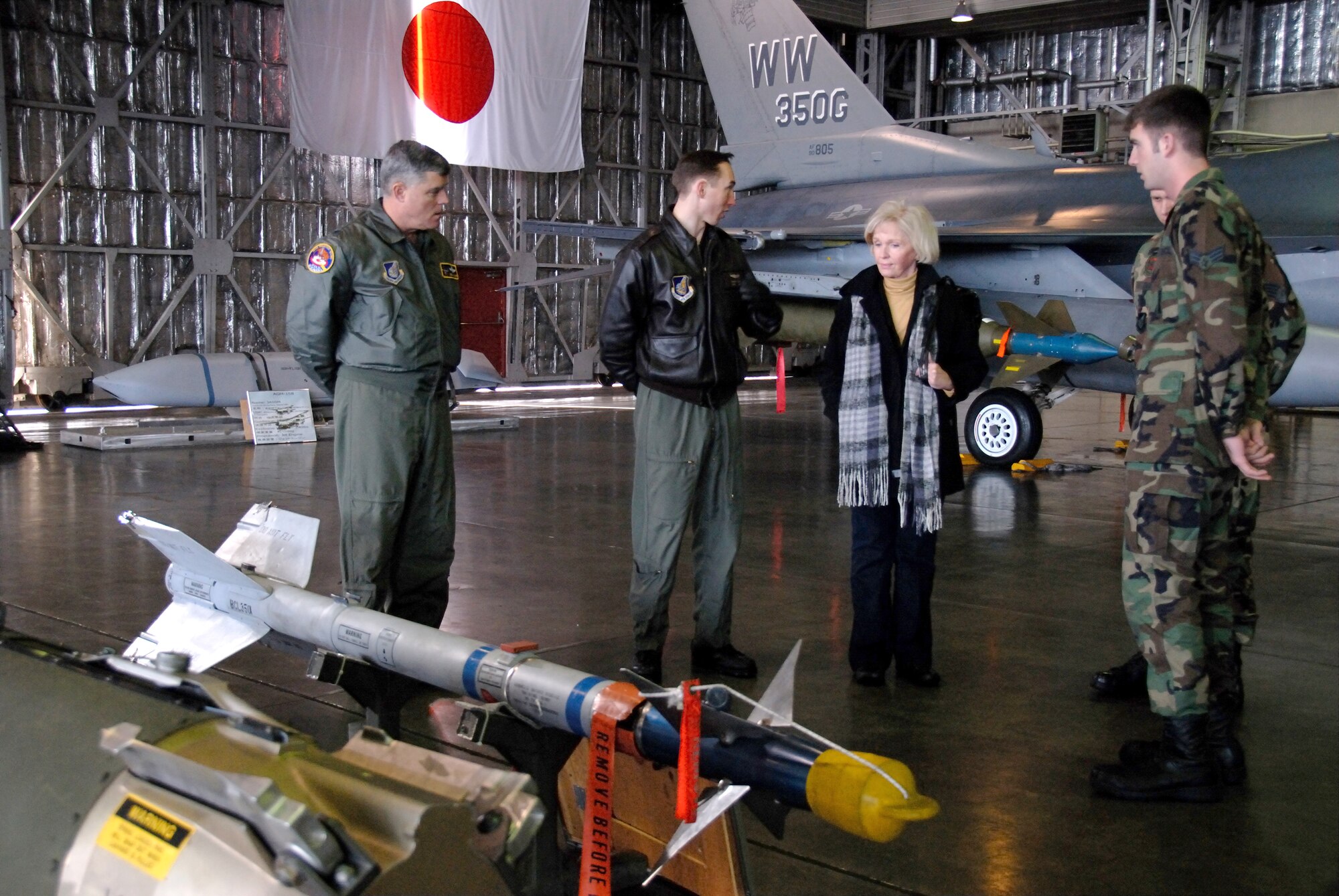 MISAWA AIR BASE, Japan -- Mrs. Earleen Burdett tours a  Misawa hanger, accompanied by Col. Joel Malone, 35th Fighter Wing vice commander, and members of the 35th Operations Group, here Jan. 19, 2008.  Mrs. Burdett was here to visit the base where her husband died in an aircraft accident in July 1960.  When asked why she wanted to visit the base more than 40 years after her husband's death she said, "With the current war, it was all coming back ... I didn't get to come over, so I wanted to come and see what he saw."  (U.S. Air Force photo by Senior Airman Laura R. McFarlane)