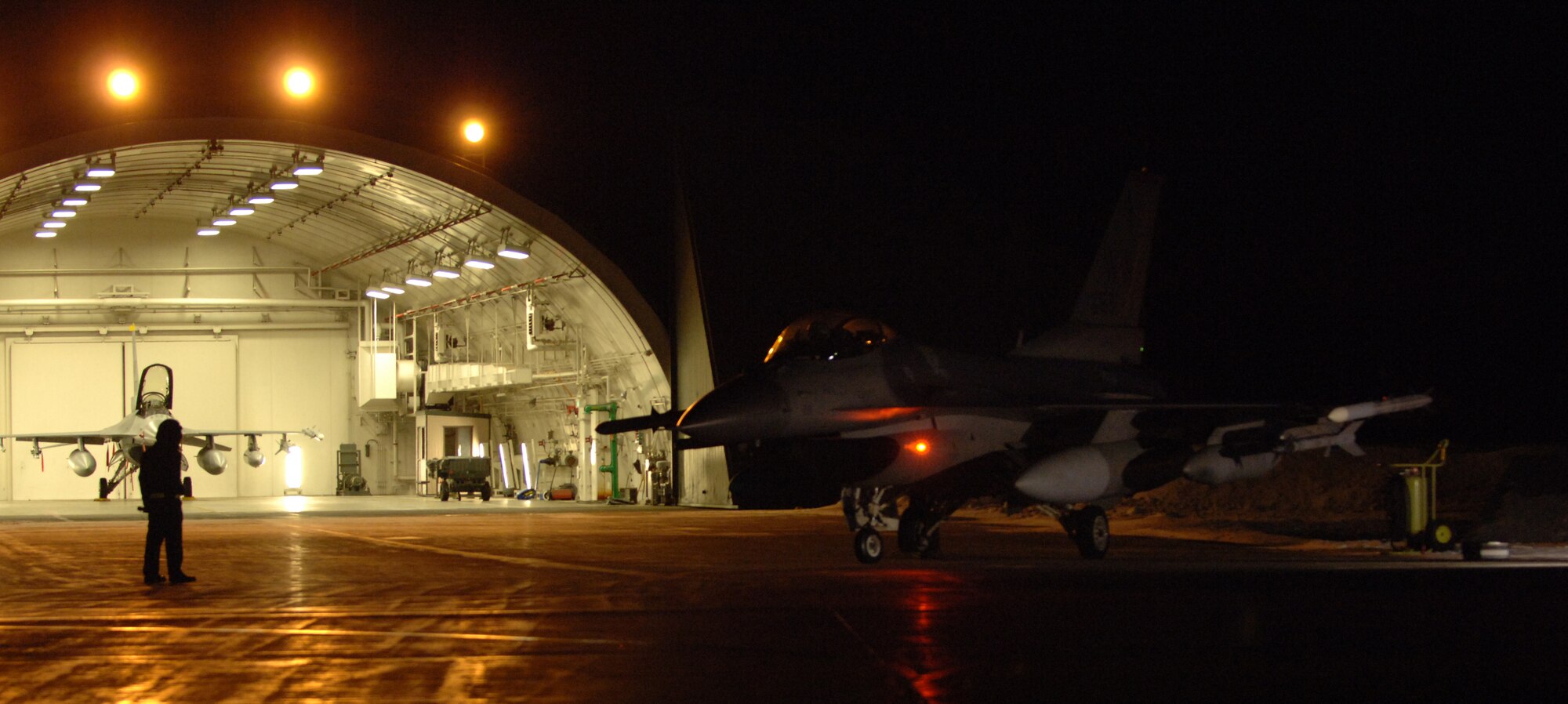 MISAWA AIR BASE, Japan -- A 13th Aircraft Maintenance Unit crew chief helps prepare an F-16 Fighting Falcon for takeoff during the early morning hours Jan. 18, 2008. Members of the 13th Fighter Squadron were headed to Eglin Air Force Base, Fla., to participate in the Combat Hammer weapons system evaluation program. (U.S. Air Force photo by Chief Master Sgt. Michael Atkinson)