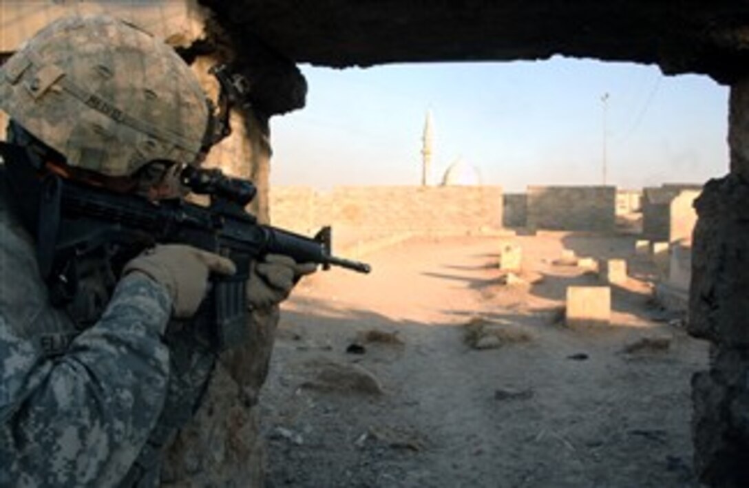 A U.S. Army soldier assigned to the 3rd Armored Cavalry Regiment peers through the entrance of a cemetery in Mosul, Iraq, Jan. 17, 2008, during a patrol.