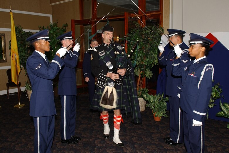 Tim Gordon, a bigpiper from Fathers of Water Pipes and Drums of Jackson, Miss., walks through a line of CAFB Honor Guardsmen holding sabers during the Kinghts of the Round Table in May. The Honor Guard helped the 43 CAFB Group and Squadron commanders pay tribute to those who have served and where lost before us in an event which mirrors the event of King Arthur and his round table. (U.S. Air Force photo)