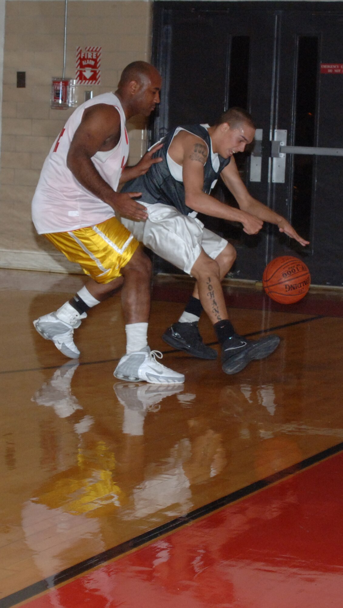 Airman Bryant Johanson, 14th Medical Group, and 1st Lt. Derrick Hodges, 14th Operations Support Suqadron, race for a loose ball in intramural basketball action Wednesday night at the Fitness Center. The 14th MDG was victorious over the 14th OSS by a score of 67 to 40. (U.S. Air Force photo by Airman 1st Class Danielle Hill)
