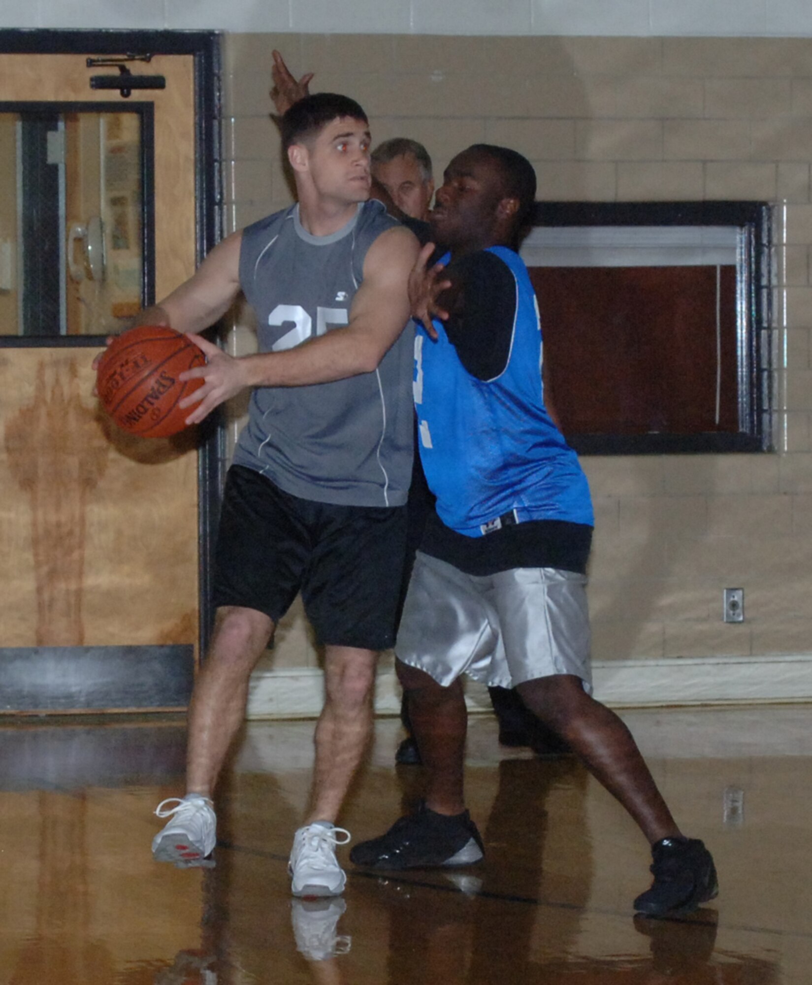 First Lt. Michael Hawkins, 14th Mission Support Group, looks for an open teammate while Airman 1st Class Tony Savage, 50th Flying Training Squadron, defends him in intramural basketball action Wednesday night. (U.S. Air Force photo by Airman 1st Class Danielle Hill)
