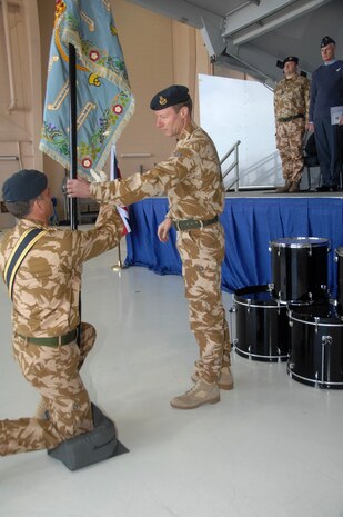CREECH AIR FORCE BASE, Nev.— Wing Commander Andy Jeffery, Royal Air Force of Great Britain, hands off the flag during an activation ceremony of the 39th United Kingdom Reaper Squadron to Flight Lt. Bert Weedon here Jan. 23. (U.S. Air Force photo by Staff Sgt. Scottie McCord)