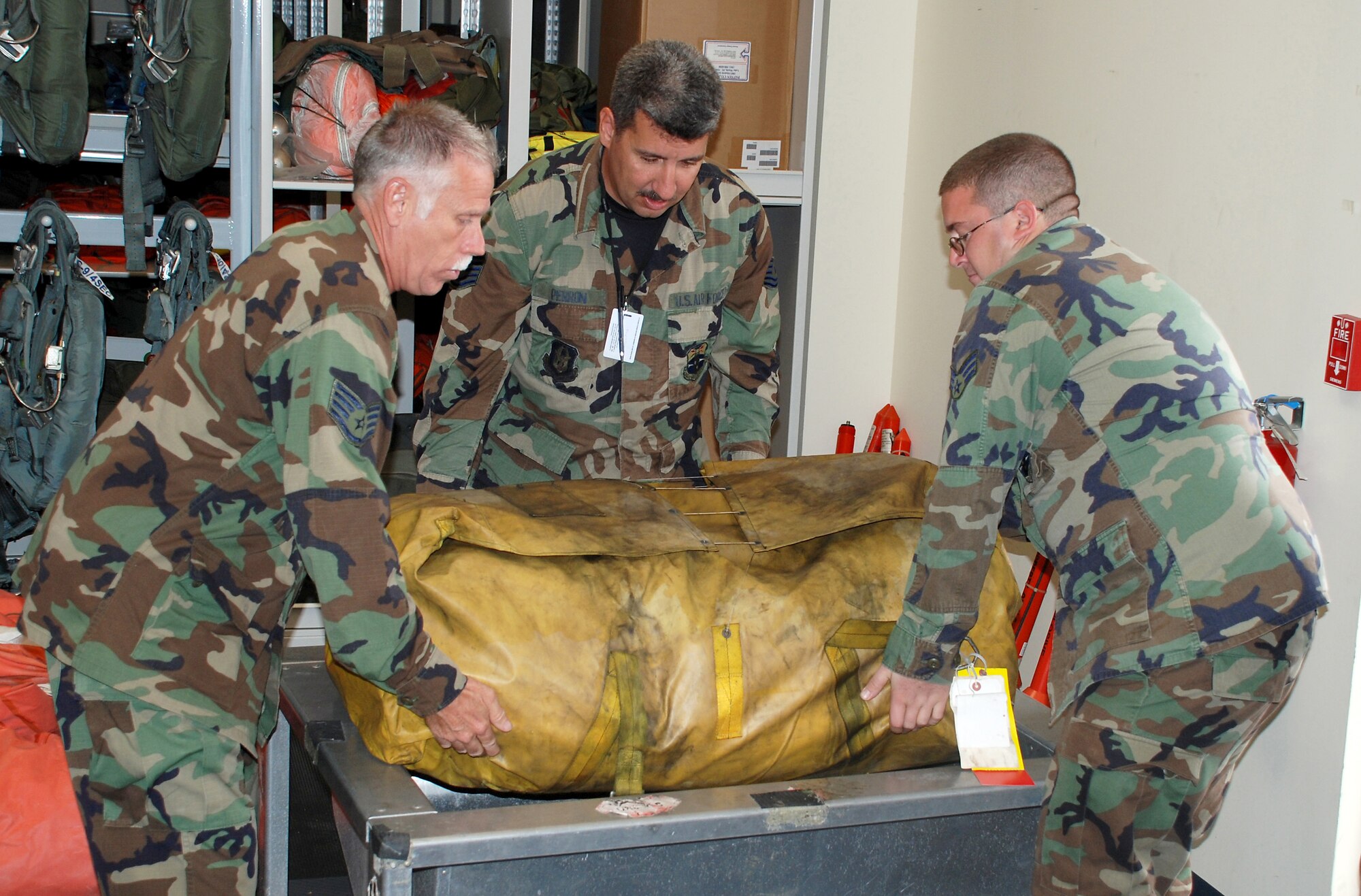 Staff Sgt. Lance Wilson, Tech. Sgt. Darryl Perron, and Senior Airman Daniel Riera from the 920th Operational Support Squadron, lift an F-2B 20-man wing-well life raft during a recent Unit Training Assembly weekend at Patrick Air Force Base, Fla. (U.S. Air Force Photo/Master Sgt. Raymond F. Padgett)