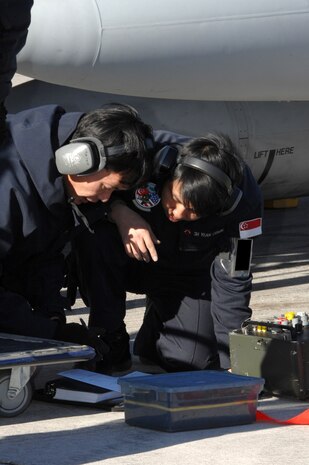 NELLIS AIR FORCE BASE, Nev.— MSG Toh Hong Sionlt and SSG Oswin Yean, from the Republic of Singapore air force, 425th Aircraft Maintenance Unit, Luke AFB, Ariz., annotate aircraft maintenance here Jan. 17. The 425th AMU is currently at Nellis participating in Red Flag 8-2.1, which is a multi-national exercise providing pilots with a realistic environment to practice combat scenarios. The experience gained during the exercise is vital to the survival of pilots in combat. The unit is assigned to Luke AFB for specialized training on their F-16 aircraft they can only receive in the U.S. (U.S. Air Force photo by Senior Airman Nadine Y. Barclay)