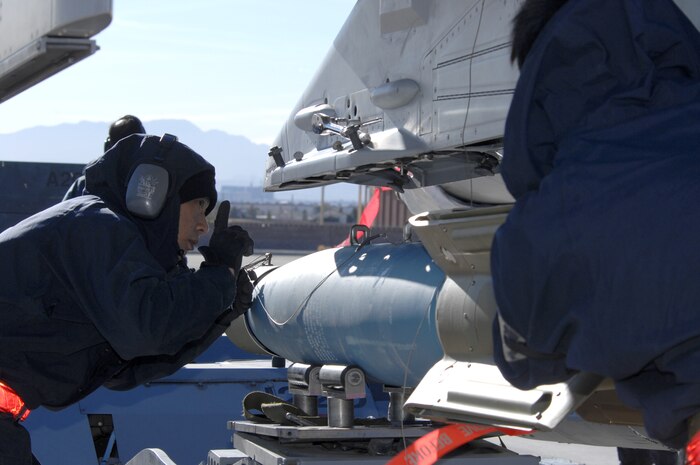 NELLIS AIR FORCE BASE, Nev.— Republic of Singapore air force member SSG Andy Ong, 425th Aircraft Maintenance Unit, Luke Base, Ariz., properly guides munitions in place on an aircraft here Jan. 17. The 425th AMU is currently at Nellis participating in Red Flag 8-2.1, which is a multi-national exercise providing pilots with a realistic environment to practice combat scenarios. The experience gained during the exercise is vital to the survival of pilots in combat. The unit is assigned to Luke AFB for specialized training on their F-16 aircraft they can only receive in the U.S. (U.S. Air Force photo by Senior Airman Nadine Y. Barclay)