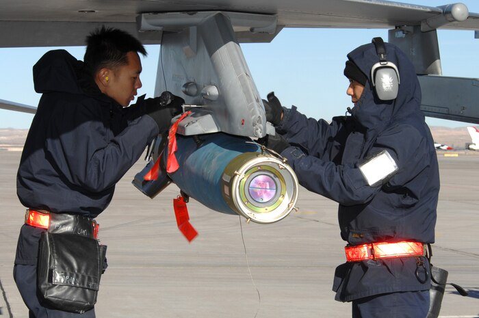 NELLIS AIR FORCE BASE, Nev.— 1SG Fabian Lim Soon Huat and SSG Andy Ong, from the Republic of Singapore air force, 425th Aircraft Maintenance Unit, Luke AFB, Ariz., load munitions onto their aircraft here Jan. 17. The 425th AMU is currently at Nellis participating in Red Flag 8-2.1, which is a multi-national exercise providing pilots with a realistic environment to practice combat scenarios. The experience gained during the exercise is vital to the survival of pilots in combat. The unit is assigned to Luke AFB for specialized training on their F-16 aircraft they can only receive in the U.S. (U.S. Air Force photo by Senior Airman Nadine Y. Barclay)