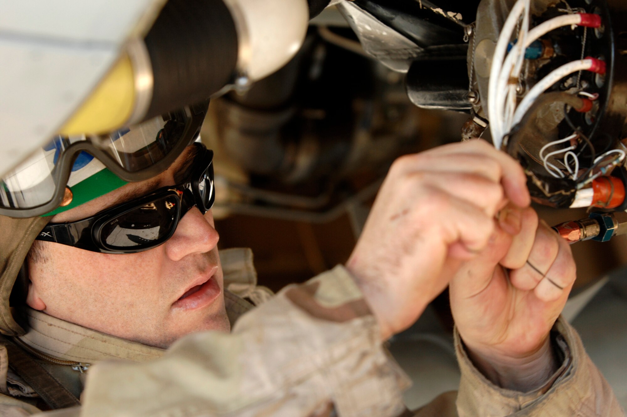 NELLIS AIR FORCE BASE, Nev.—Petty Officer 2nd Class Patrick Kinbell, 134th Electronic Attack Squadron, Naval Air Station Whidbey Island, Wash., tapes up a wiring harness on the engine of an EA-6 Prowler during preventive maintenance on the aircraft here Jan 17. Petty Officer Kinbell is at Nellis with his unit participating in Red Flag 8-2.1, which is a multi-national exercise providing pilots with a realistic environment to practice combat scenarios. The experience gained during the exercise is vital to the survival of pilots in combat. (U.S. Air Force photo by Master Sgt. Robert W. Valenca)
