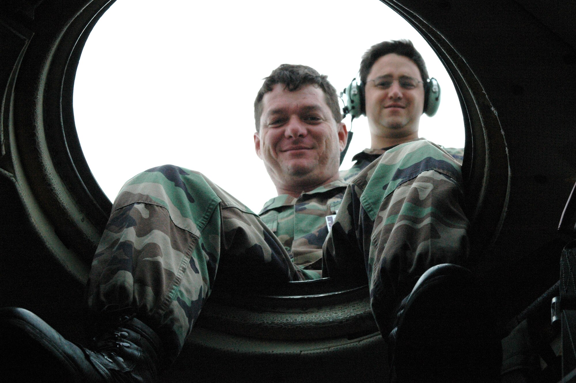 Tech. Sgt. David Ruggles (center) and Staff Sgt. Jeremy Buck (right), crew chiefs with the 920th Rescue Wing Aircraft Maintenance Squadron, peer down from an escape hatch atop an HC-130 Hercules aircraft during a routine inspection on the aircraft.  (U.S. Air Force Photo/Staff Sgt. Heather L. Kelly)