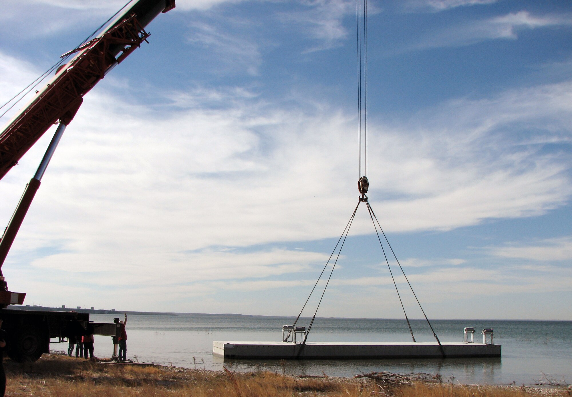 LAUGHLIN AIR FORCE BASE, Texas—Contractors offload a single section of a state-of-the-art breakwater into Lake Amistad Jan. 9.  After placing all three sections into the water, a barge and winch were used to maneuver the pieces over to Southwinds Marina. (U.S. Air Force photo by Mike Easterly)