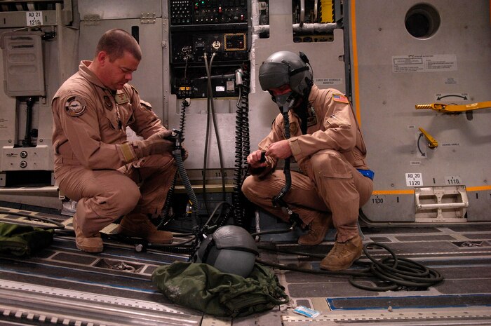 Tech. Sgt. Brad Pilgrim and Staff Sgt. Chris Koch preflight their oxygen equipment on a C-17 Globemaster III for a Joint Precision Airdrop Delivery System of 40 bundles of humanitarian supplies to a drop zone Jan. 14 in Afghanistan. Sergeants Pilgrim and Kock are loadmasters from the 17th Airlift Squadron from Charleston Air Force Base, S.C., and are deployed to the 816th Expeditionary Airlift Squadron in Southwest Asia. (U.S. Air Force photo/Master Sgt. Andy Dunaway) 
