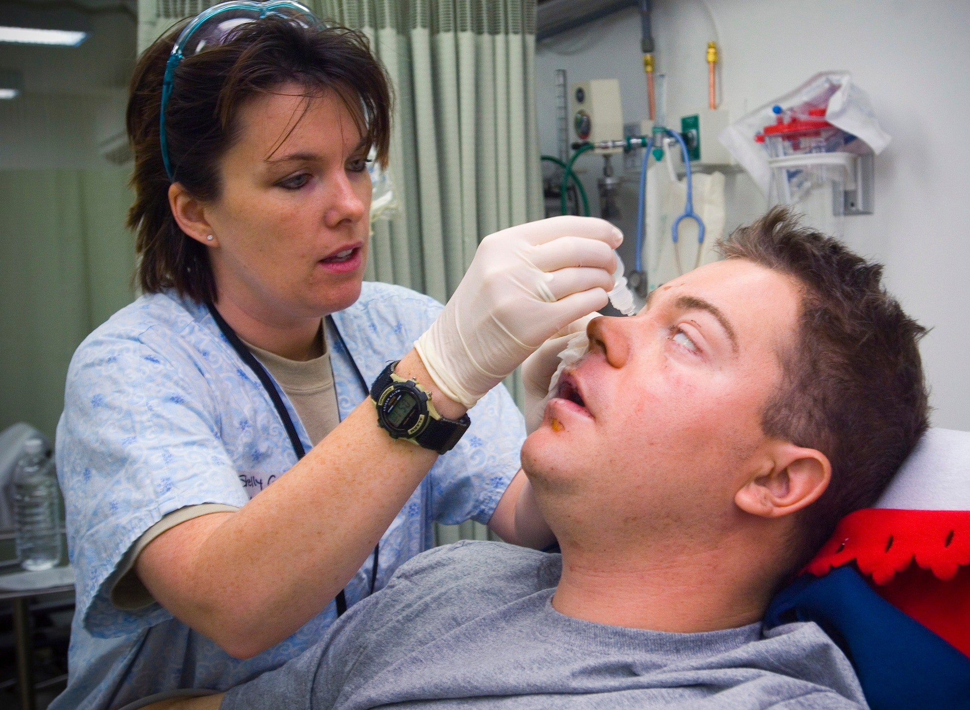 Capt. Shelly Garceau gives Army Spc. Christopher Burrell eye drops at the Air Force Theater Hospital at Balad Air Base, Iraq. Specialist Burrell, a member of the 108th Military Police Company, suffered burns and lost his leg as a result of an explosive formed penetrator in an attack near Sadr City. Capt. Garceau is an emergency room nurse deployed from Wilford Hall Medical Center, San Antonio, Texas. (U.S. Air Force photo/Tech. Sgt. D. Clare)