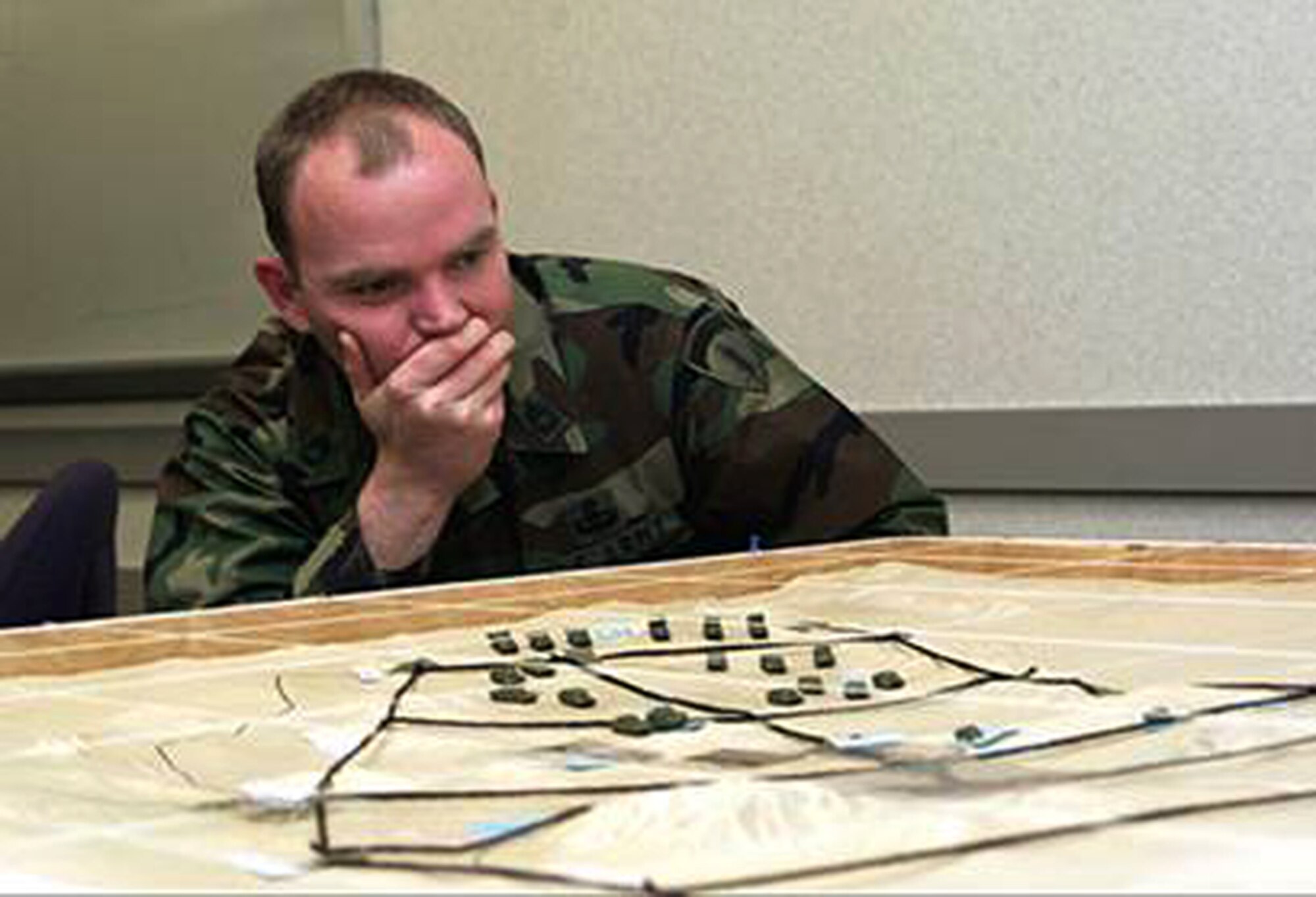 A Joint Terminal Attack Controller contemplates his next course of action on a sand table previously used to train JTAC students here in 2004. The 57th Operations Group acquired a JTAC Virtual Trainer dome Jan. 17, for training JTACs in a state-of-the-art, virtual environment. (Courtesy photo)