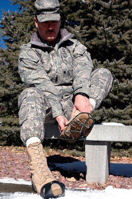 Senior Master Sgt. Michael S. Blakely, 302nd Airlift Wing Civil Enginiering flight, samples two common variations of traction slip-ons sold at Clothing Sales on base.  Jan 2008 has had some of the heaviest snowfall on record with bitter temperatures for Peterson Air Force Base, Colo, which adds increased risk for slips and falls that can be costly to airmen and their units. (U.S. Air Force photo/Staff Sgt. Derrick M. Gildner)