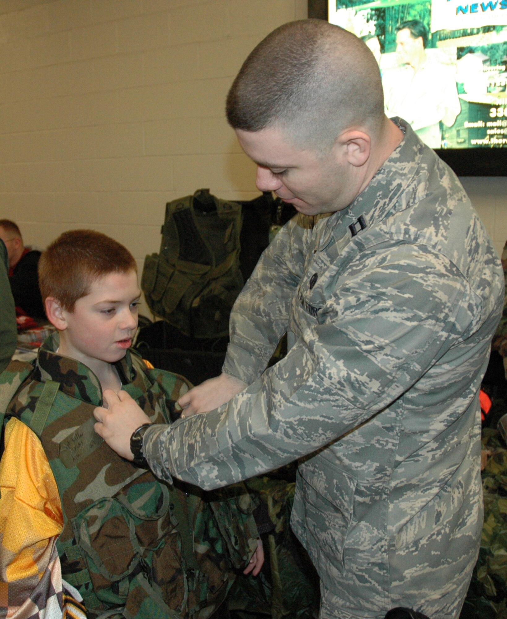 YOUNGSTOWN, Ohio – Air Force Reserve Capt. Steve Kellar, operations officer with the 910th Security Forces Squadron, helps a young boy try on a flack jacket that was part of a display at the Chevrolet Centre Jan. 19. 2008.  The event was part of Military Night at the Youngstown Steelhounds hockey game against the Shreveport Mudbugs.  U.S. Air Force photo/Tech. Sgt. Bob Barko Jr.