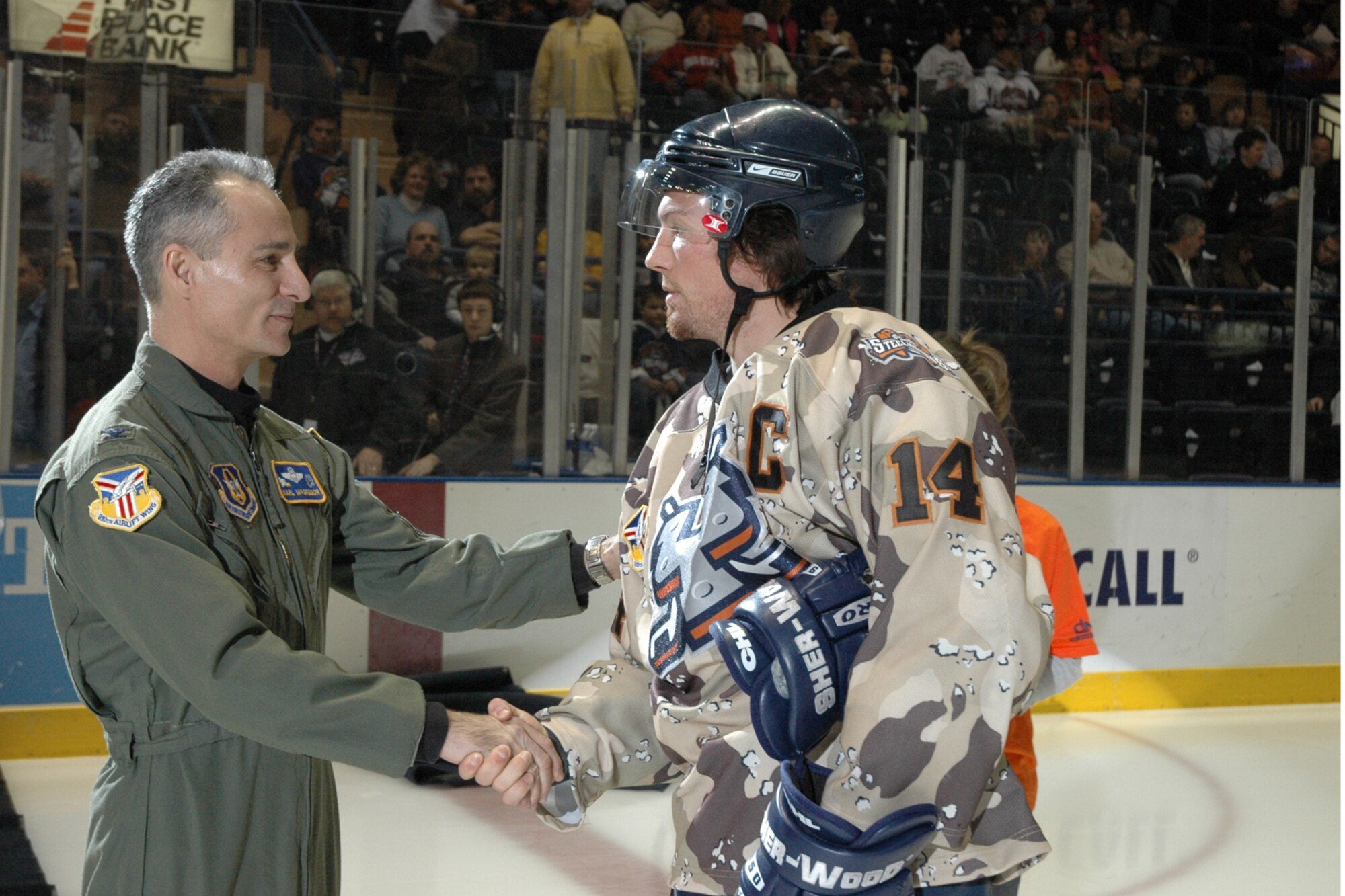 YOUNGSTOWN, Ohio – Air Force Reserve Col. Karl McGregor, commander of the 910th Airlift Wing, presents his Commander's Coin of Excellence to Chris Richards, Captain of the Youngstown Steelhounds hockey team at the Chevrolet Centre Jan. 19, 2008 during Military Night ceremonies prior to the Steelhounds game against their CHL rival Shreveport Mudbugs. U.S. Air Force photo/Tech. Sgt. Bob Barko Jr.