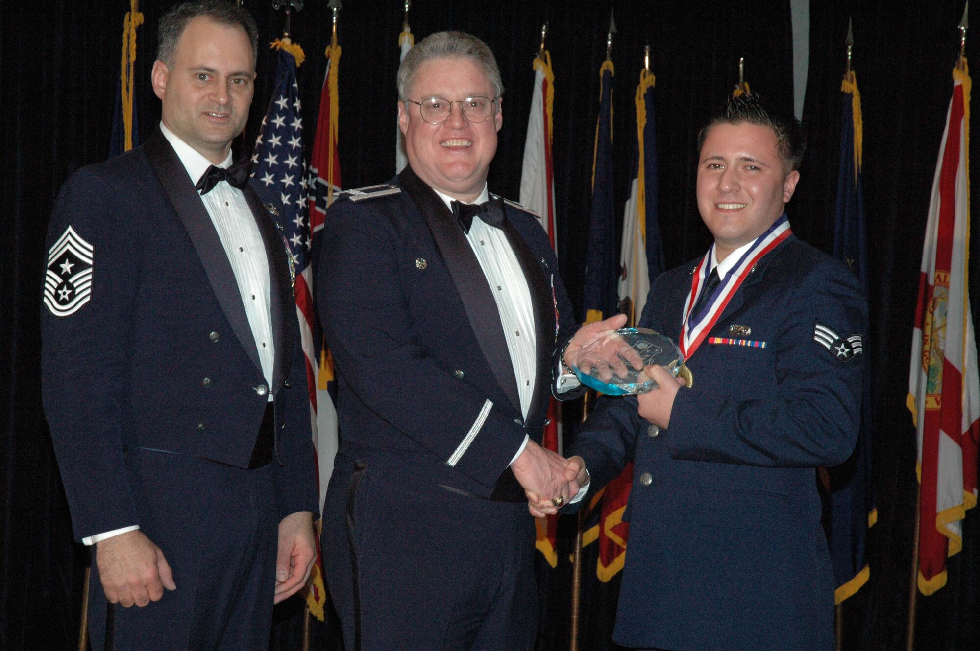 MCGUIRE AIR FORCE BASE, N.J. -- Senior Airman Mario J. Aochoa, right, of the 514th Communication Squadron receives the 514th Air Mobility Wing Airman of the Year 2007 Award from Col. James L. Kerr, middle, and Command Chief Master Sgt. Michael J. Ferraro, left, Jan. 12 during the 8th annual awards banquet. (U.S. Air Force photo/Senior Airman William P. O'Neil III)
