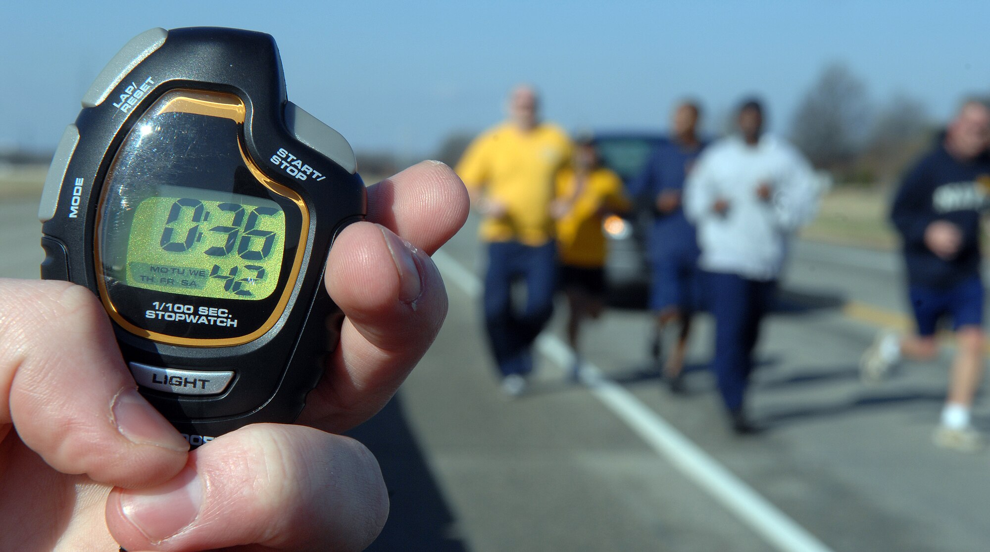 LANGLEY AIR FORCE BASE, Va. -- Airman 1st Class Richard Everidge, 1st Services Squadron apprentice, holds a timer as Sailors from the Precommissioning Unit, George H.W. Bush Aircraft Carrier, make their way to the finish line during the 5K Polar Bear Run here Jan. 23. The winners of the 5K are as follows: Women Under 34 category – Adonis White; Men Under 34 category – Jamal Lofton; Men 35-49 category – John DeGoes; Men 50 and Over category – George Hays. (U.S. Air Force photo/Airman 1st Class Vernon Young)