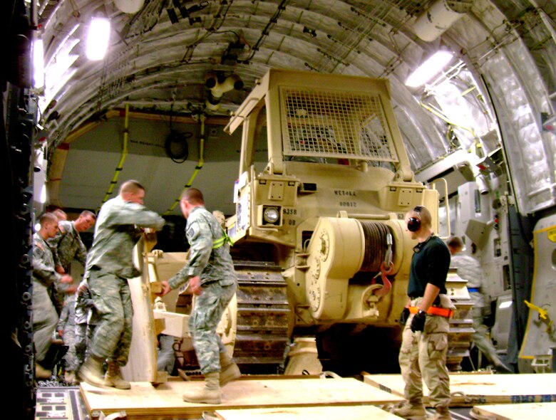 Airmen, deployed to the 332nd Expeditionary Logistics Readiness Squadron, Detachment 4, Marine Corp Air Base Al Taqaddum, Iraq, work together with transient Soldiers to off load Army Corps of Engineers equipment. (U.S. Air Force photo/Staff Sgt. Jodi Pepin)