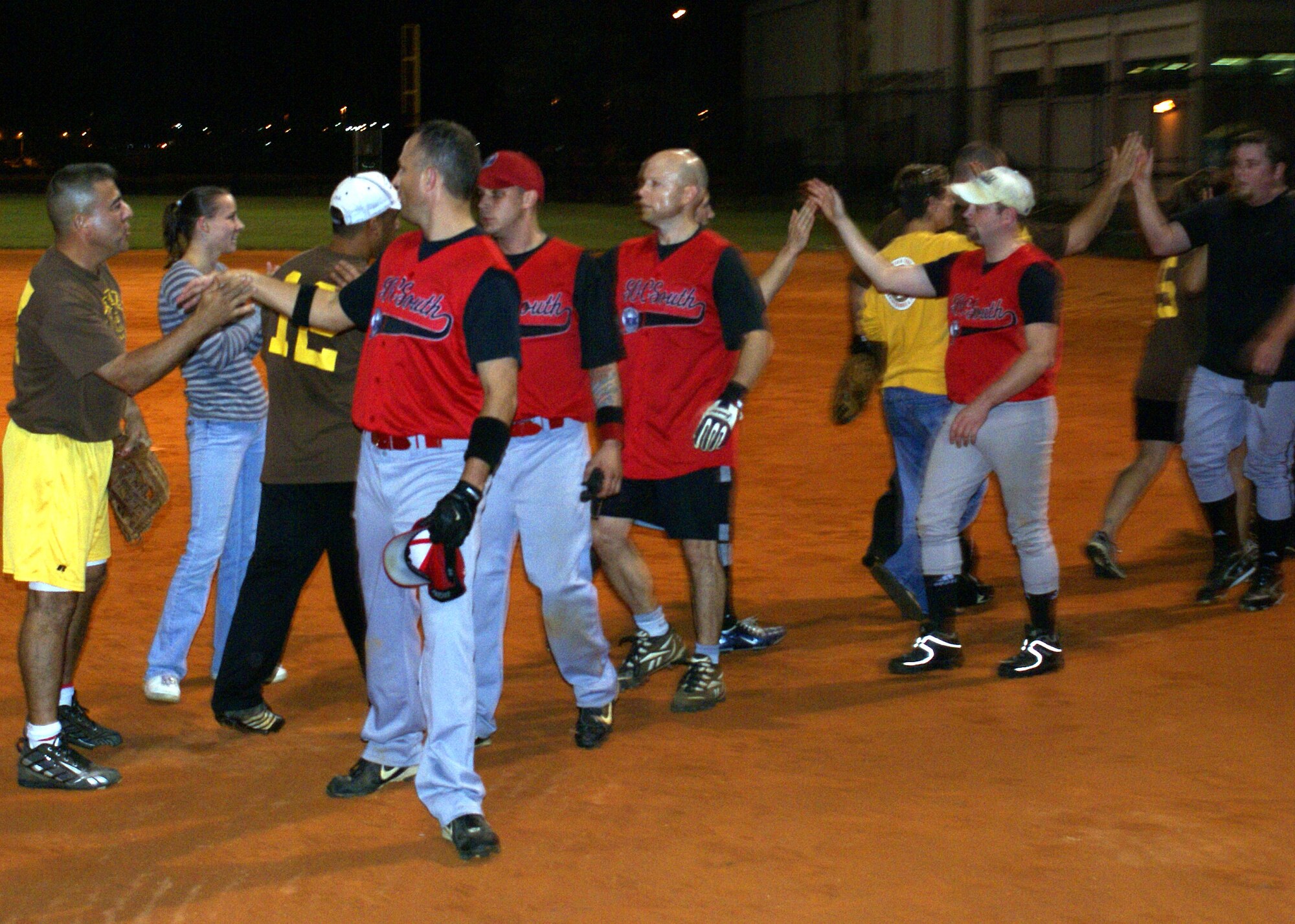 Players from the Grease Monkeys and Special Operations Command South go through the congratulatory handshake line after the Grease Monkeys defeated SOCSOUTH 5-4 to win the Homestead Air Reserve Base championship intramural softball game on Jan. 22. (U.S. Air Force photo/Senior Airman Erik Hofmeyer)