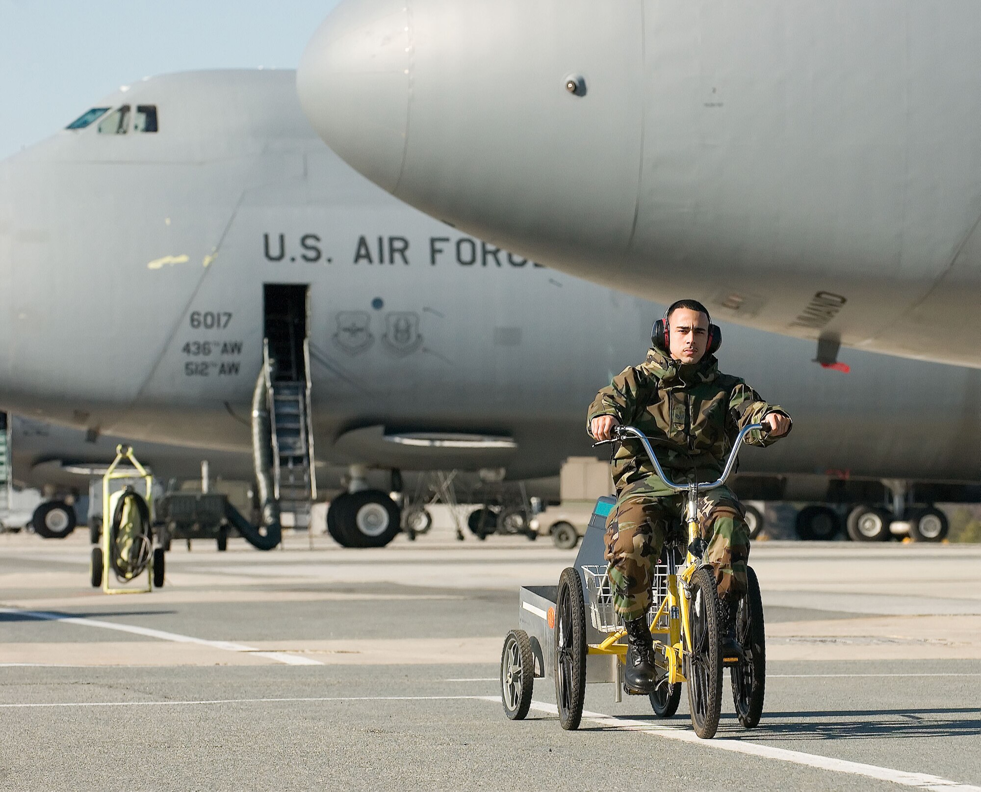 Staff Sgt. Jorge Vargas, 436th Maintenance Squadron, operates a non-motorized cycle to transport parts to a C-5 Galaxy at Dover Air Force Base recently. The cycles are environmentally-safe and have been in use since 1977 at the base. The cycles require no fuel and their frequent usage creates zero waste by-products. The cycles also require minimal maintenance, and as an added bonus, they provide operators the opportunity to work out and help keep Airmen fit to fight. (U.S. Air Force photo/Jason Minto)