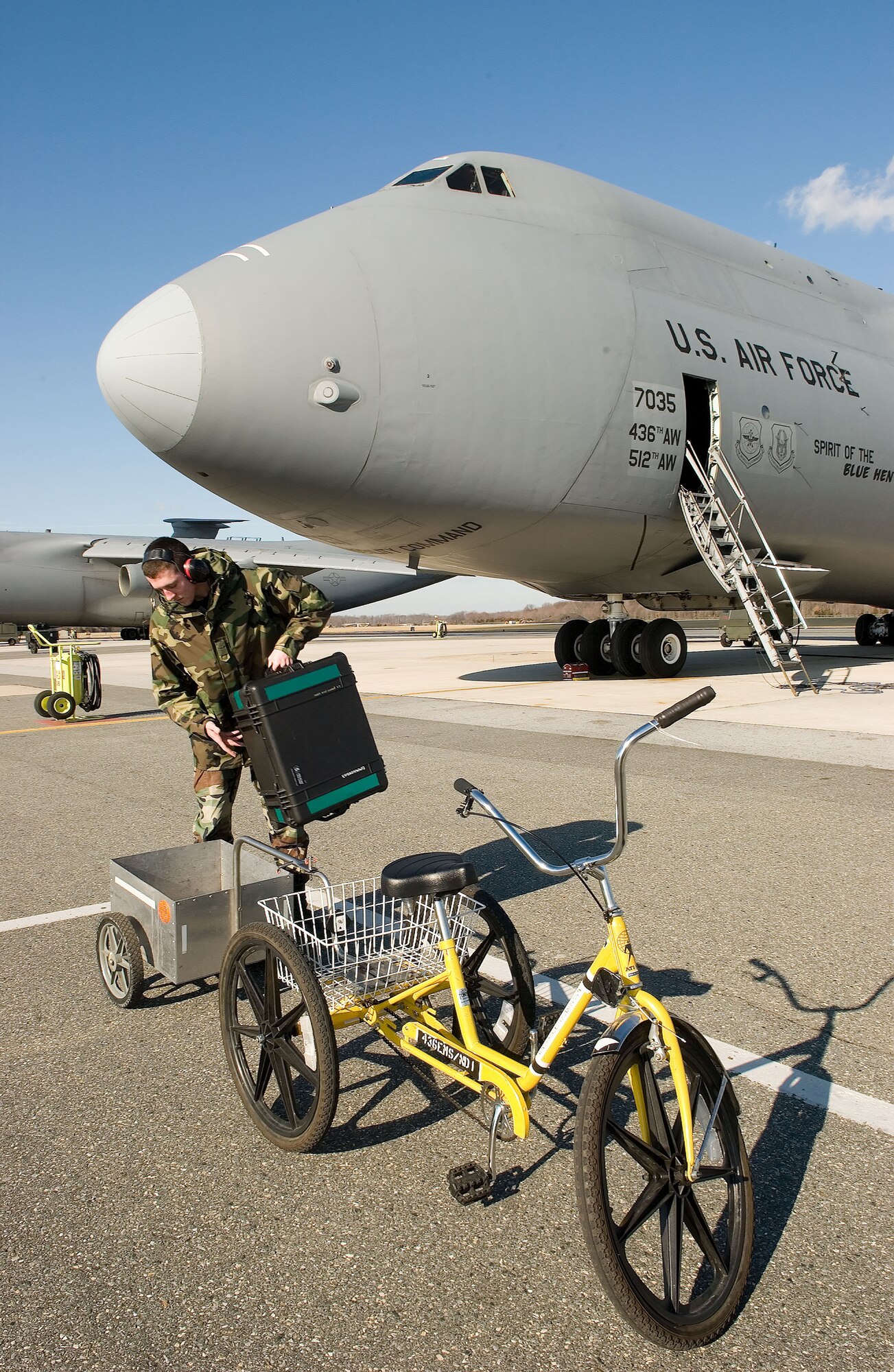"Green" practices Airman Joshua Paserb, 436th Maintenance Squadron, operates a non-motorized cycle to transport parts to a C-5 Galaxy at Dover Air Force Base recently. The cycles are environmentally-safe and have been in use since 1977 at the base. The cycles require no fuel and their frequent usage creates zero waste by-products. The cycles also require minimal maintenance, and as an added bonus, they provide operators the opportunity to work out and help keep Airmen fit to fight. (U.S. Air Force photo/Jason Minto)
