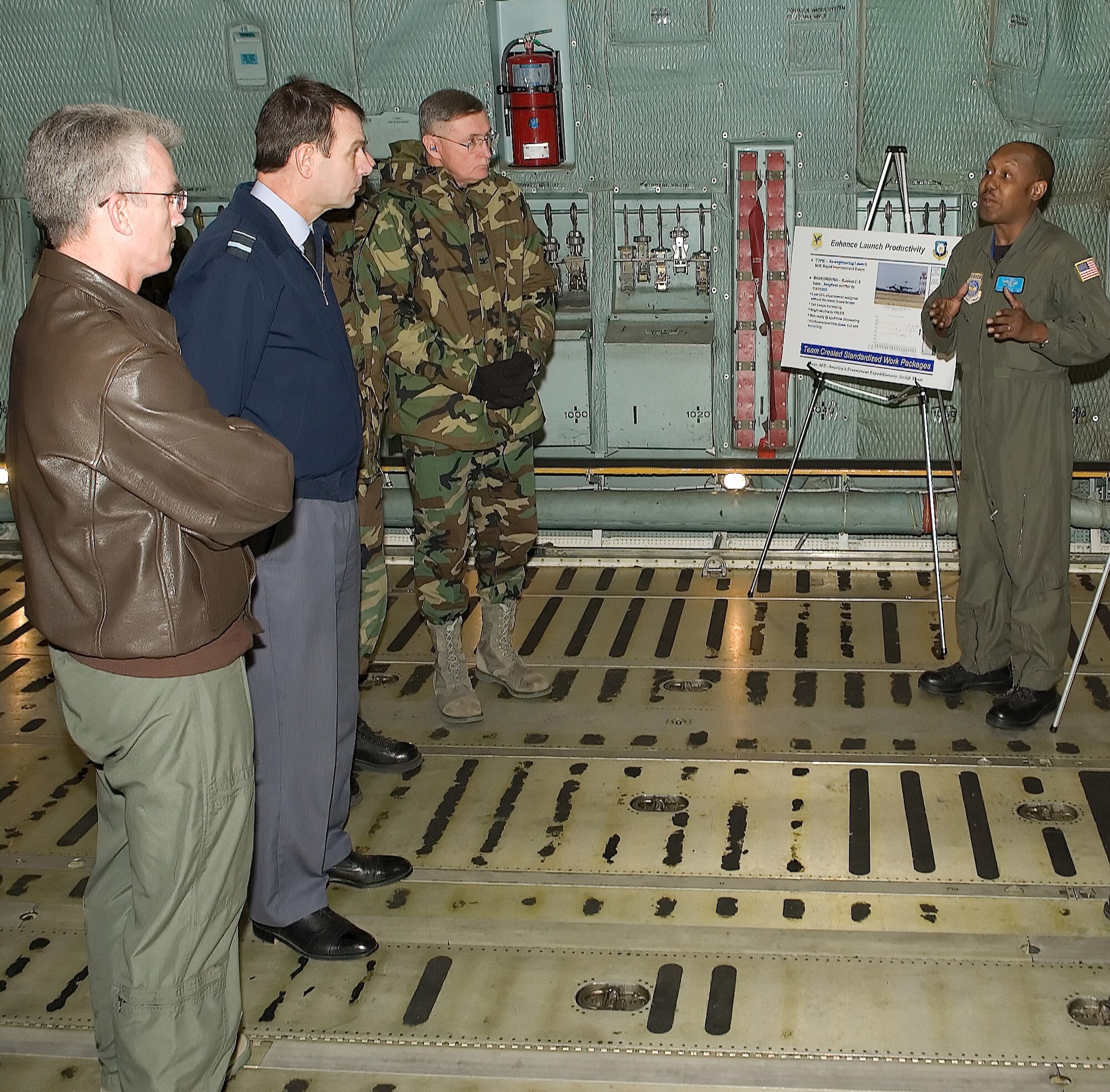 Maj. Gen. Paul Selva, director of Air Force Smart Operations of the 21st Century, Royal Air Force Air Vice-Marshall Peter Dye, chief of transformation for the RAF, and Col. Dennis Daley, 436th Maintenance Group commander, listen recently as Master Sgt. Dexter Joseph, 9th Airlift Squadron flight engineer instructor, describes process improvements implemented at Dover Air Force base that have increased efficiency.  The briefing was part of a tour showcasing and sharing improvement ideas with AF and RAF leadership that save man-hours as well as taxpayer dollars while increasing overall efficiency of the base. (U.S. Air Force photo/Jason Minto)