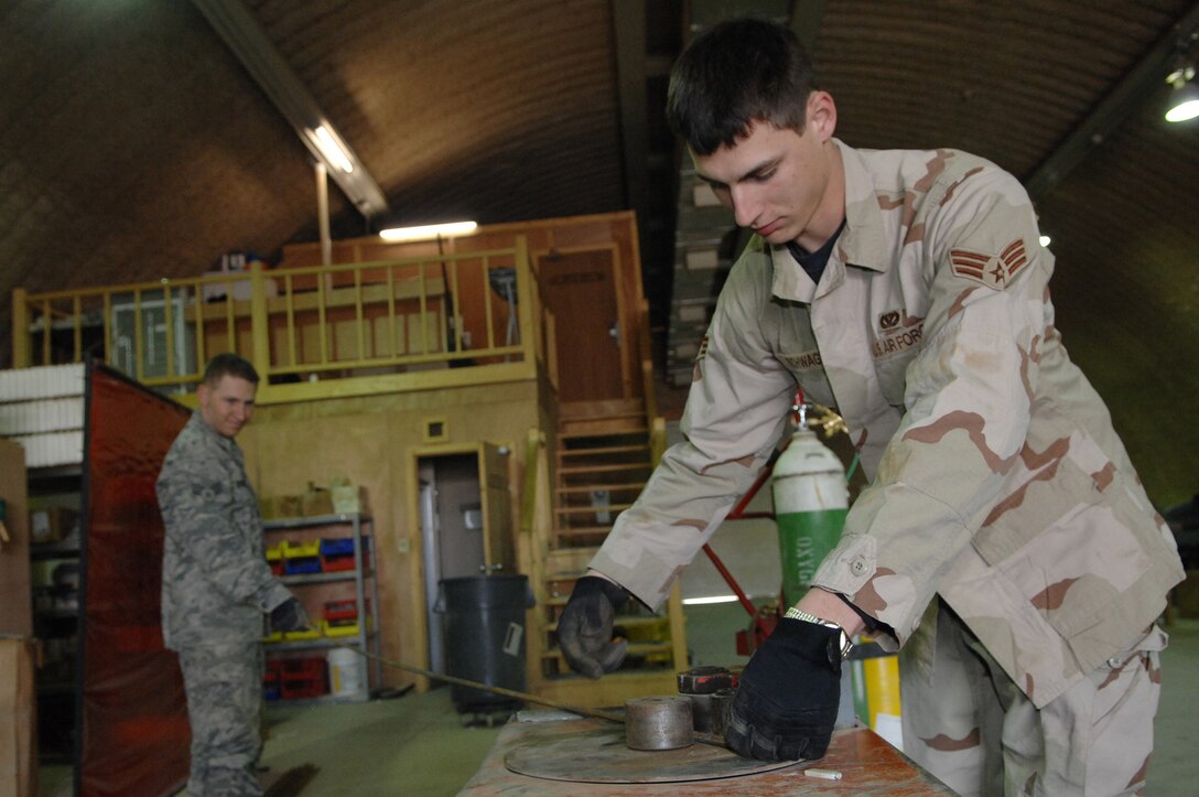 BALAD AIR BASE, Iraq -- Senior Airman Jason Schwager, 332nd Expeditionary Civil Engineer Squadron structural craftsman, bends rebar for reinforcement in a concrete pad here, Jan. 21. Rebar is positioned in ladder formation at a sight prior to pouring concrete to help reduce cracks. Airman Schwager is deployed from Ellsworth Air Force Base, S.D. (U.S. Air Force photo/ Senior Airman Julianne Showalter) 