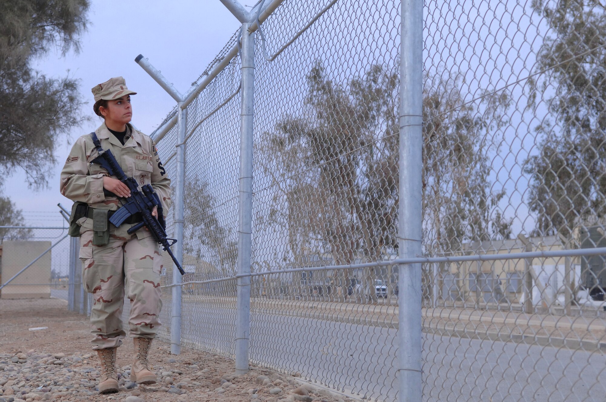 BALAD AIR BASE, Iraq -- Airman 1st Class Hollie-Anne Burgess, 332nd Expeditionary Security Forces Squadron, examines a stretch of fence line here, Jan 22. Airman Burgess is deployed from Spangdahlem Air Base, Germany.(U.S. Air Force photo/Senior Airman Julianne Showalter) 