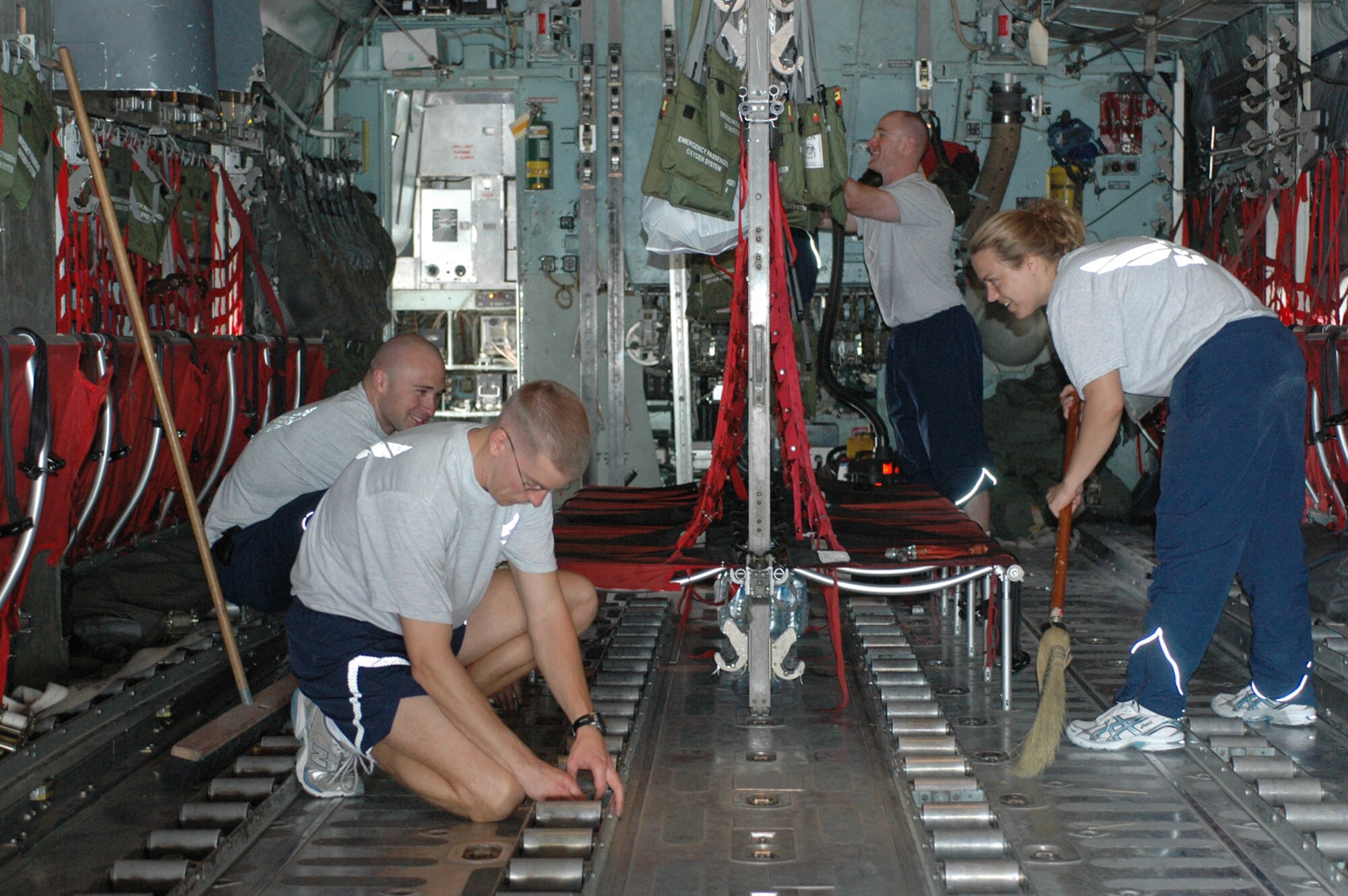 SOUTHWEST ASIA -- Crew members and maintainers from the 40th Expeditionary Airlift Squadron and 379th Expeditionary Aircraft Maintenance Squadron deployed from Dyess Air Force Base, Texas, clean the inside of a C-130 Jan. 23. Once a week, crew members volunteer to help the maintainers clean a different Herk as part of a unit cohesion initiative. This Dyess-specific morale event brings the two squadrons together to work toward a common goal that's tangible and instantly beneficial to the overall intratheater airlift mission of the group. (U.S. Air Force photo/Senior Airman Carolyn Viss)