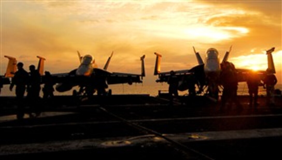 The sun silhouettes aircraft on the flight deck of the Nimitz-class nuclear-powered aircraft carrier USS Harry S. Truman in the Persian Gulf, Jan. 18, 2008. 